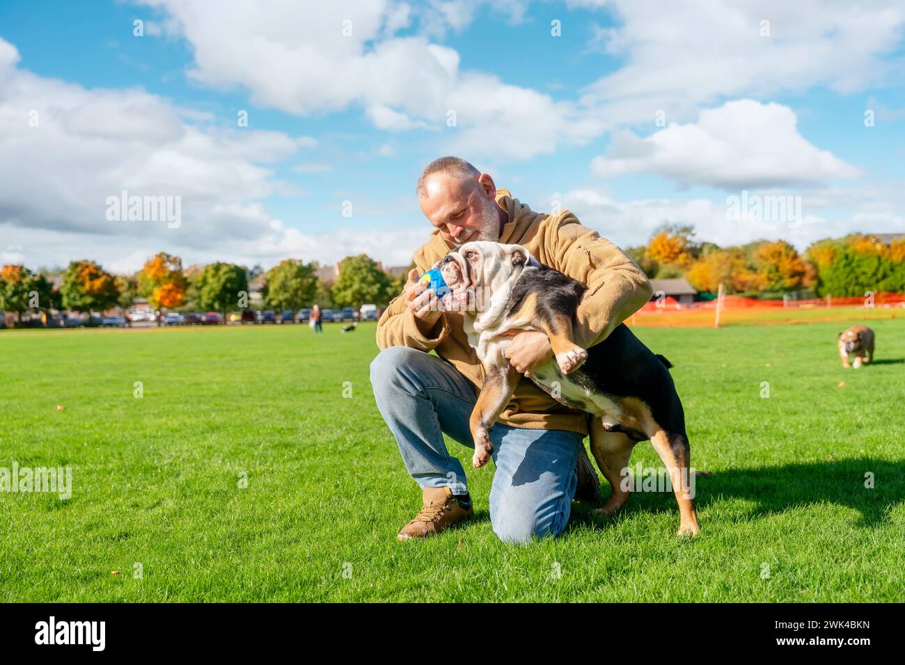 Ein alter Mann, der mit seinem Hund im Park spielt Stockfoto