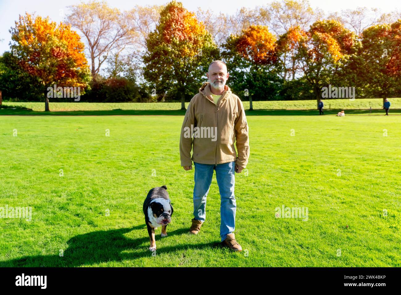 Ein alter Mann, der mit seinem Hund im Park läuft Stockfoto