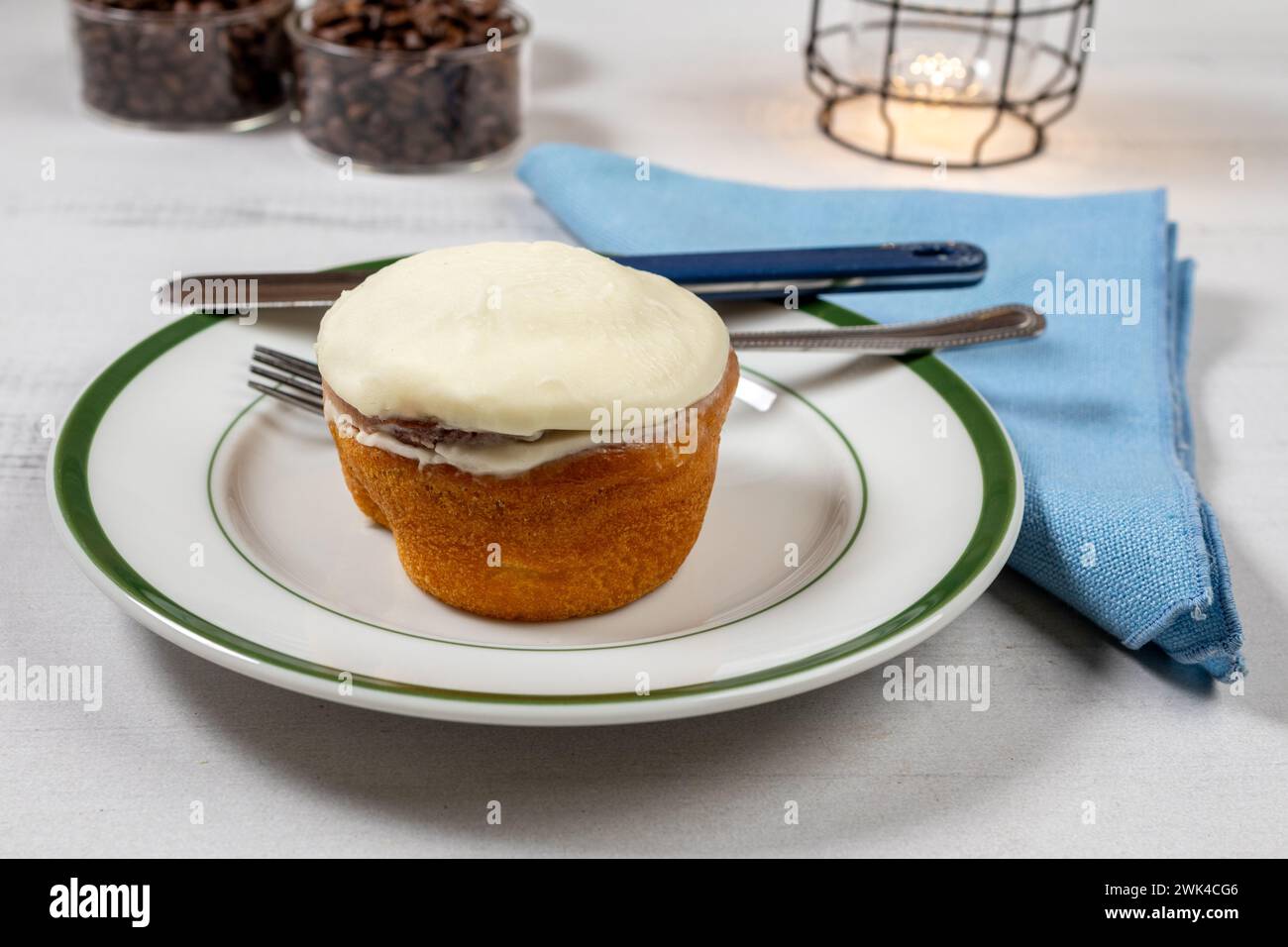 Zimtbrötchen, Kaffeebohnen, Lampe und Kaffeebohnen auf Holztisch Stockfoto