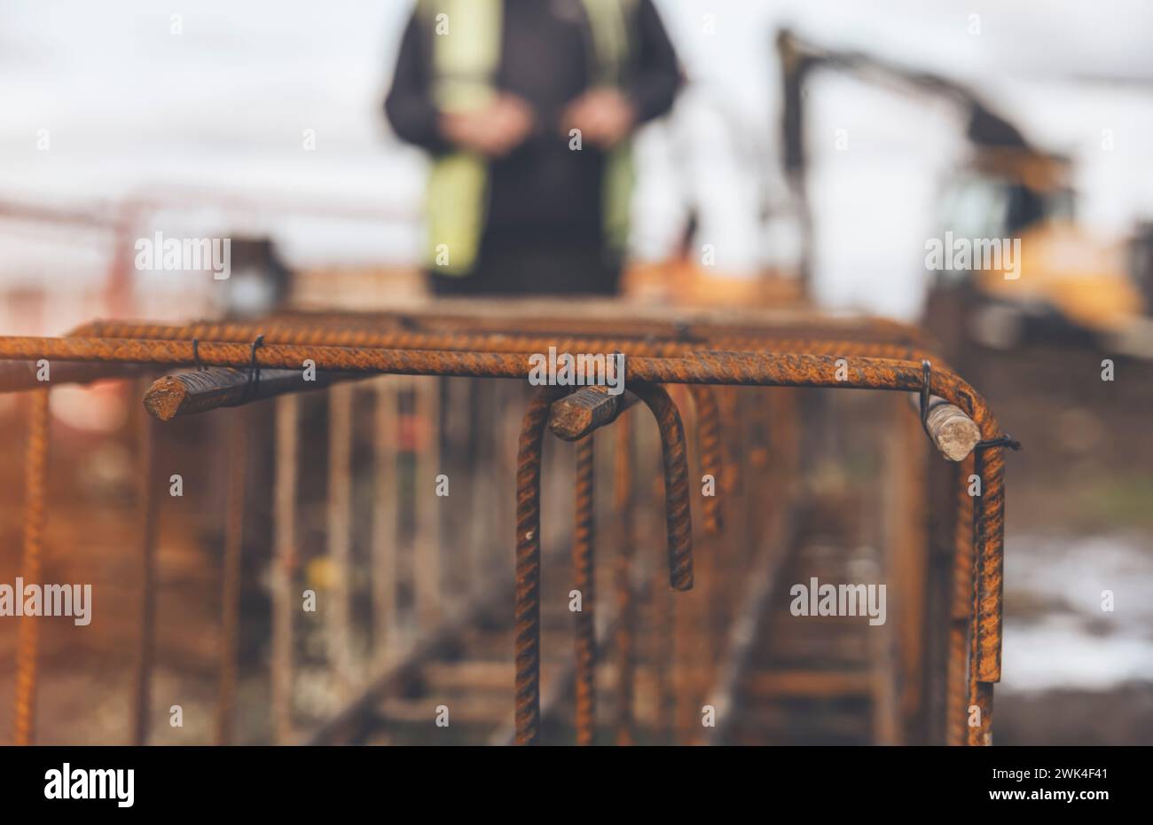 Ein Arbeiter verwendet Stahlbindedraht, um Stahlstäbe in Nahaufnahme an Verstärkungsstäben zu befestigen. Stahlbetonkonstruktionen - Herstellung eines Stahlverstärkungskäfigs f Stockfoto