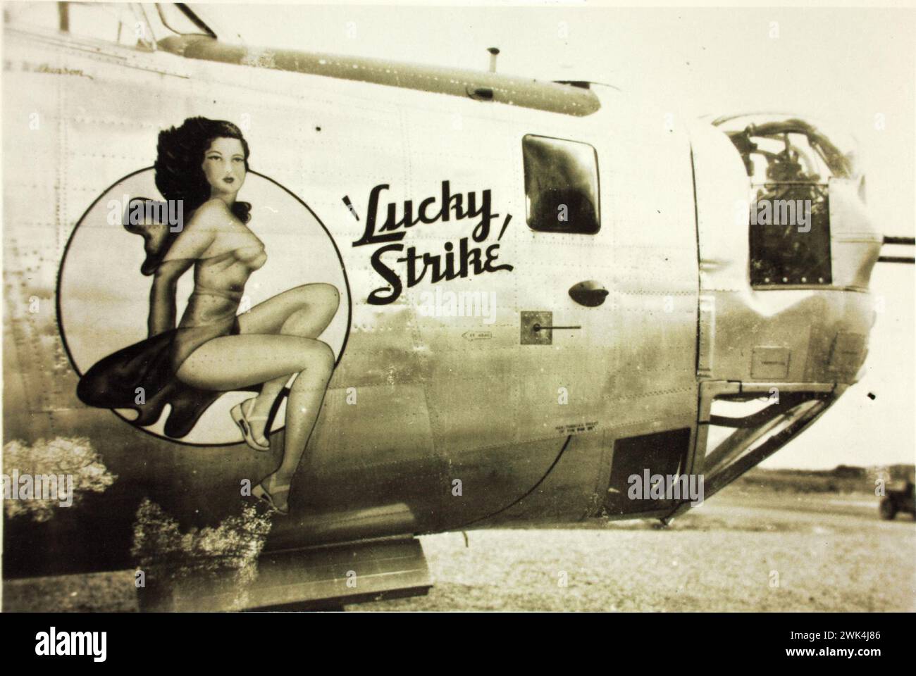 Vorderseite eines 380th Bomb Group Consolidated B-24 Liberator Militärflugzeugs, mit einem "Lucky Strike" und einer Frau auf dem Rumpf gemalt. Vintage-Foto 1940er Jahre Stockfoto