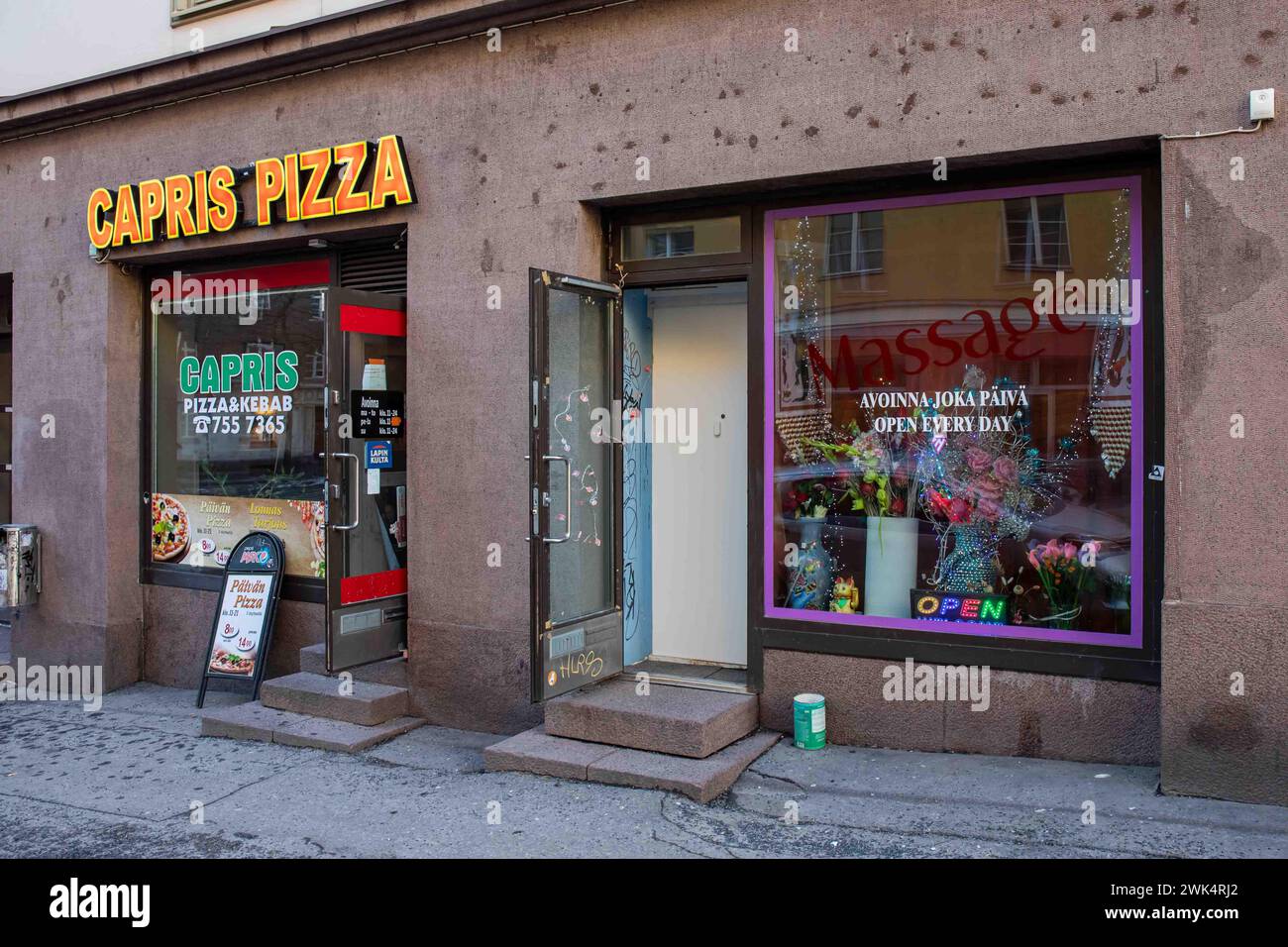 Pizza und Kebab Place Capris Pizza neben dem Massagesalon im Kustaankatu im Bezirk Harju in Helsinki, Finnland Stockfoto