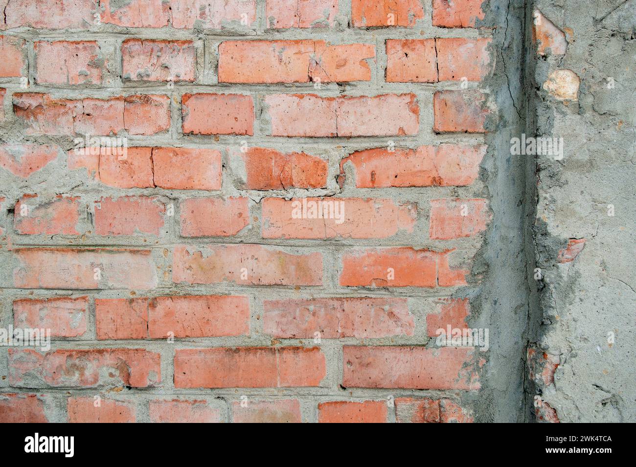 Handgefertigte Ziegelwand aus Ziegeln, abstrakte Hintergrundtextur mit altem schmutzigem Muster im Vintage-Stil. Roter Schleifstein in der Wand mit grauem pu Stockfoto