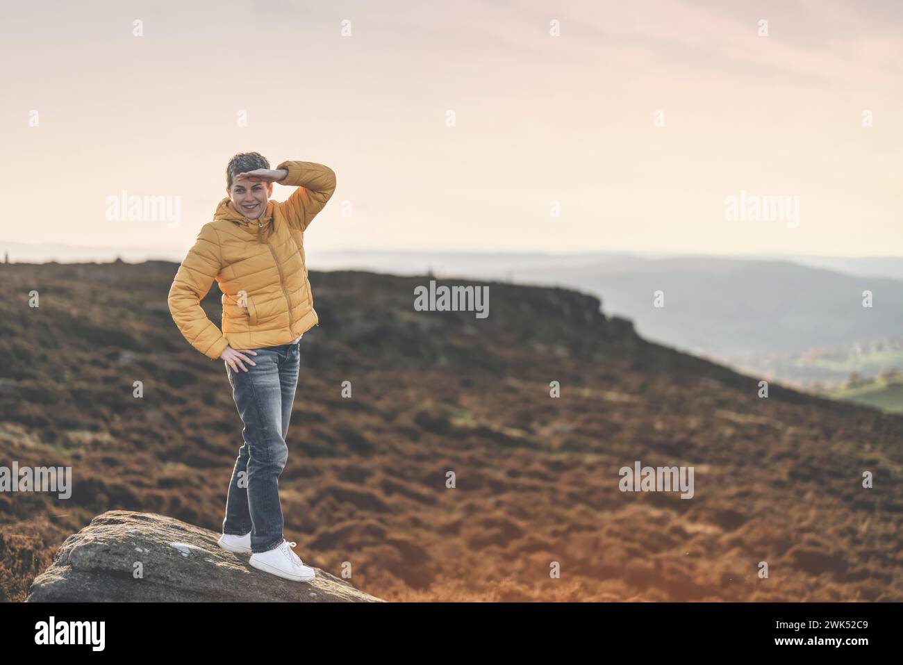 Frau Wandern in den Bergen, um Zeitpläne von Sonnenaufgang, Bewegung und Fitness für Wellness, gesunden Lebensstil und Lächeln zu nehmen. Senior reifer Gentleman sitzt Stockfoto