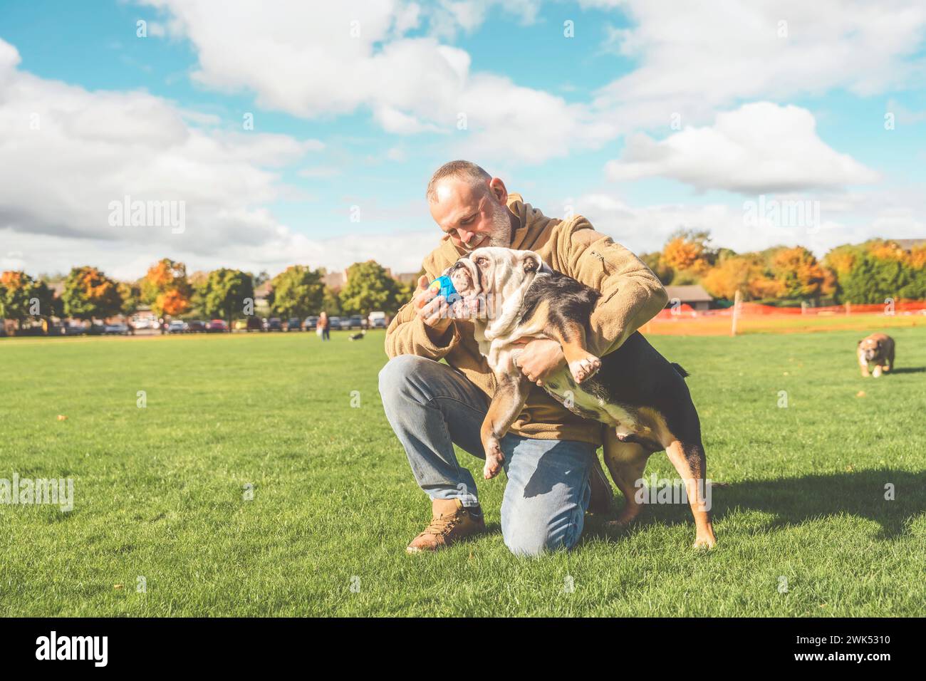 Ein alter Mann, der mit seinem Hund im Park spielt Stockfoto