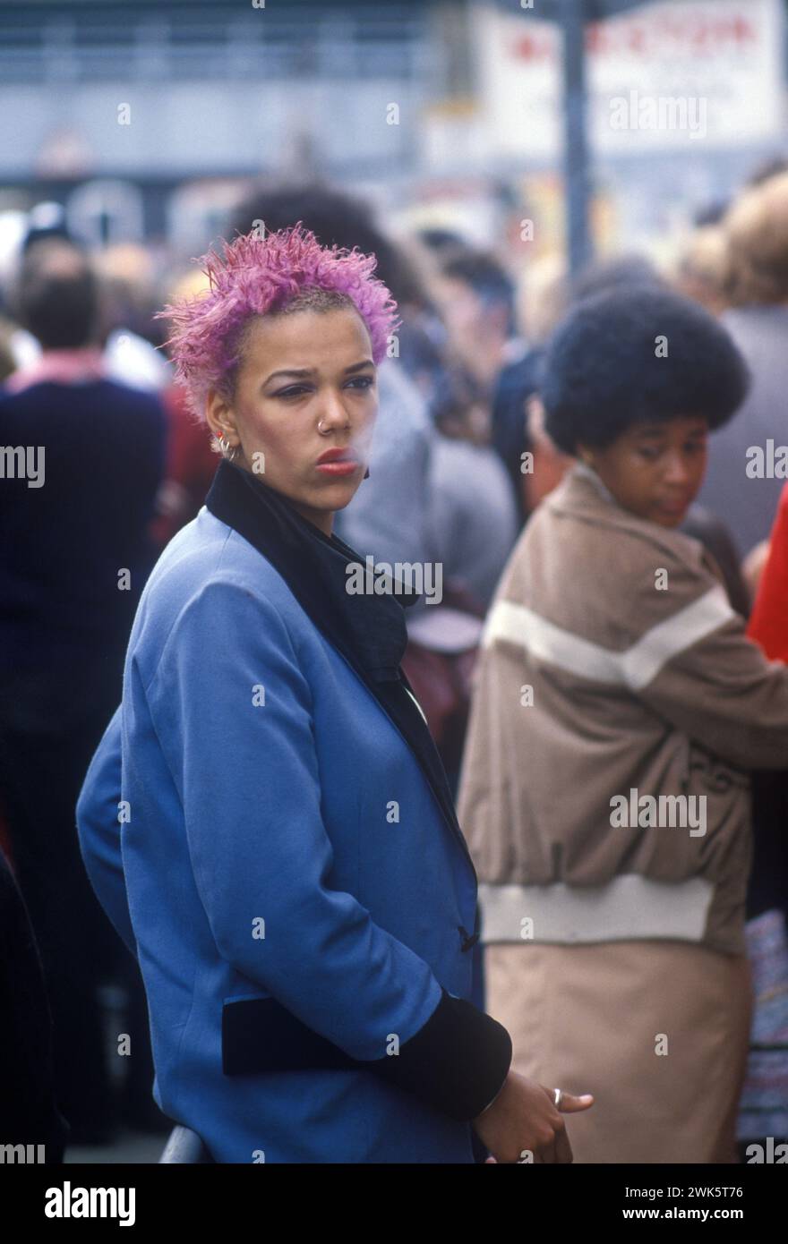 Street Fashion 1980s UK. Schwarze britische POC-Frau, die an einem Samstagnachmittag 1983 die King Road Chelsea London entlang geht. England HOMER SYKES Stockfoto