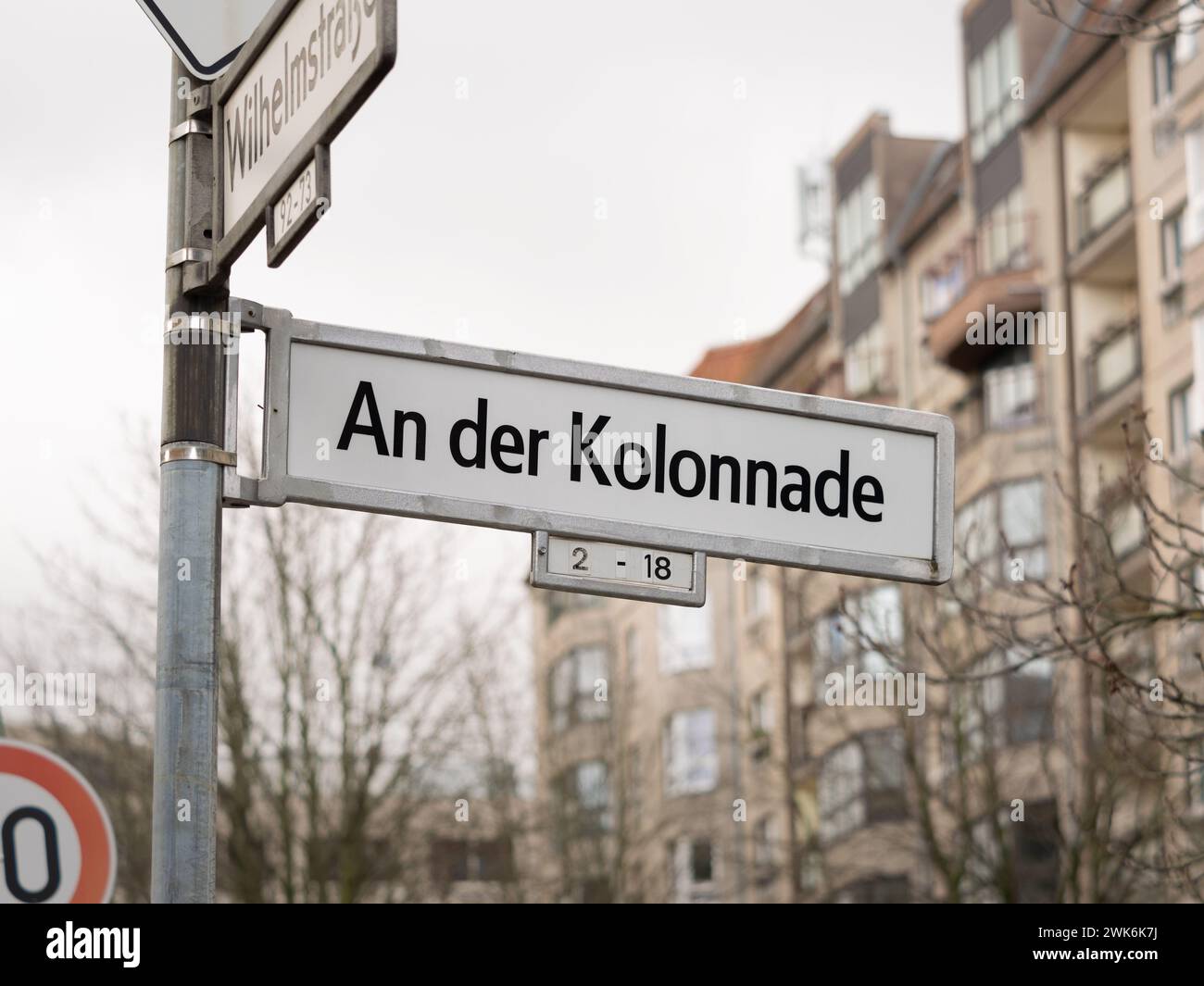 An der Kolonnade in Berlin. Schild mit dem Straßennamen an einer Kreuzung. In der Gegend befindet sich ein Wohnviertel mit sozialistischer Architektur. Stockfoto