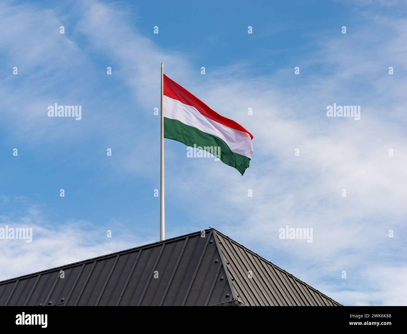 Ungarische Flagge auf dem Dach eines Regierungsgebäudes. Symbol des Landes Ungarn in Europa und Zeichen für eine internationale Partnerschaft. Stockfoto