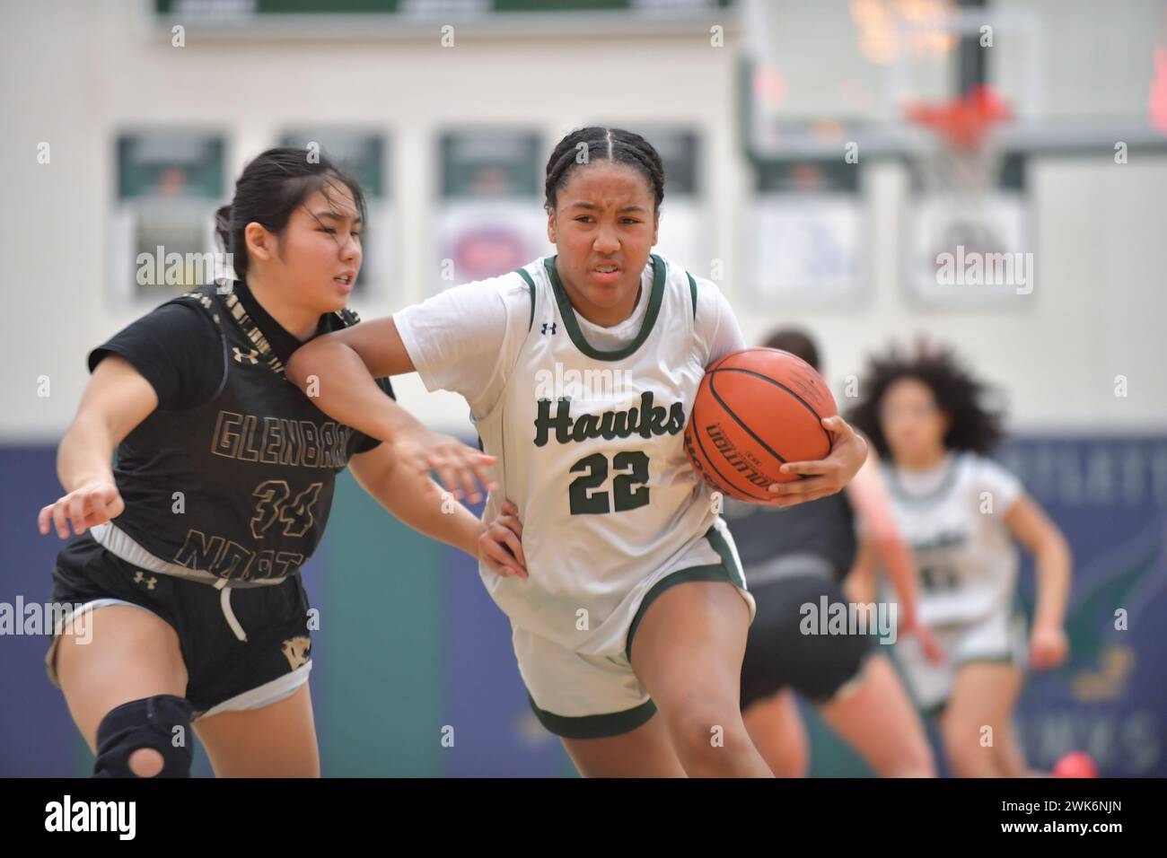 Illinois, USA. Beim Vorwärtsfahren wird ein Ellbogen verwendet, um einen Verteidiger vom Ball fernzuhalten, während er zum Basketball fährt. Stockfoto