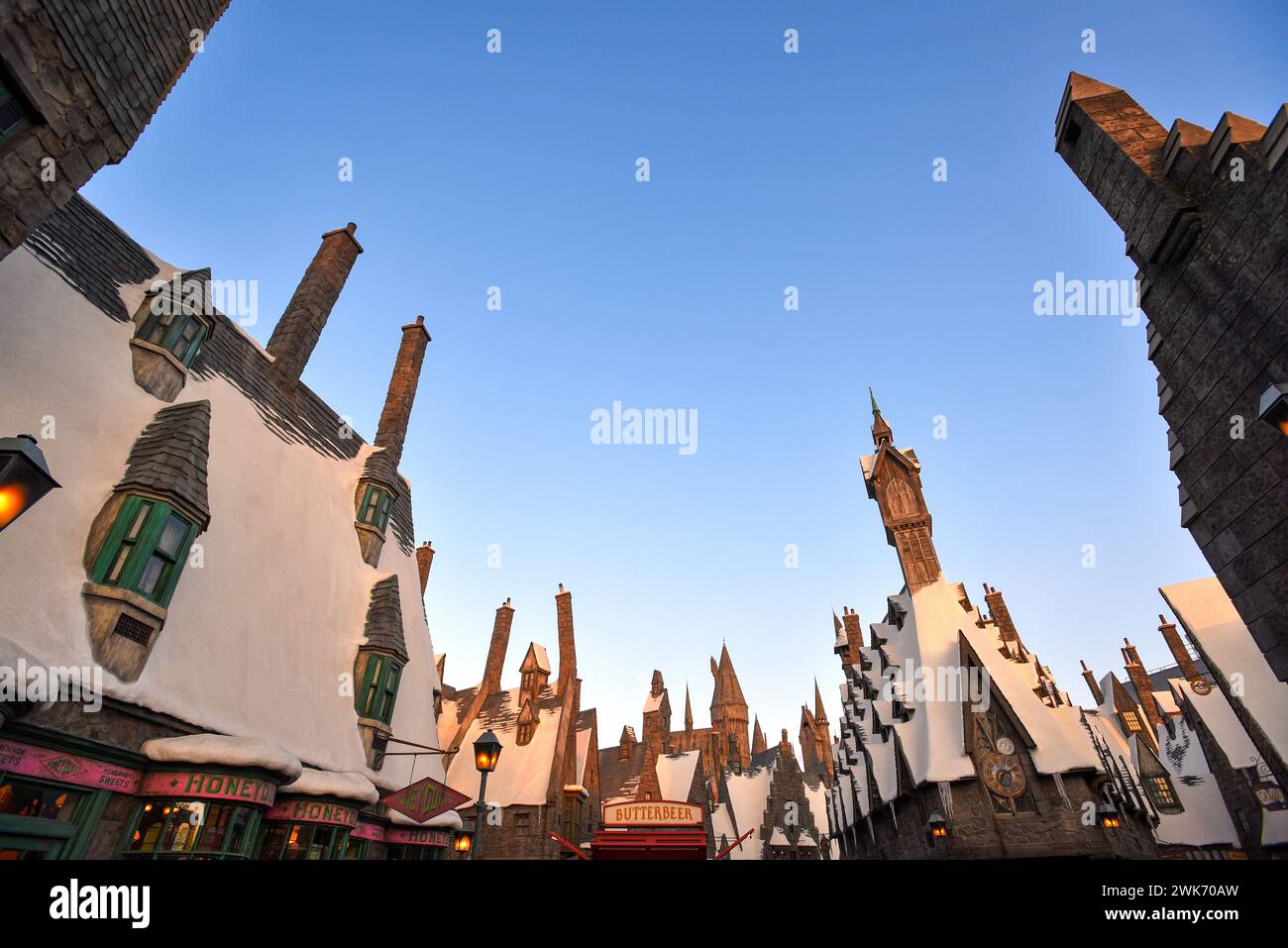 In der Wizarding World of Harry Potter in den Universal Studios Hollywood - Los Angeles, Kalifornien, können Sie die Abenddämmerung über den Dächern des Hogsmeade Village genießen Stockfoto