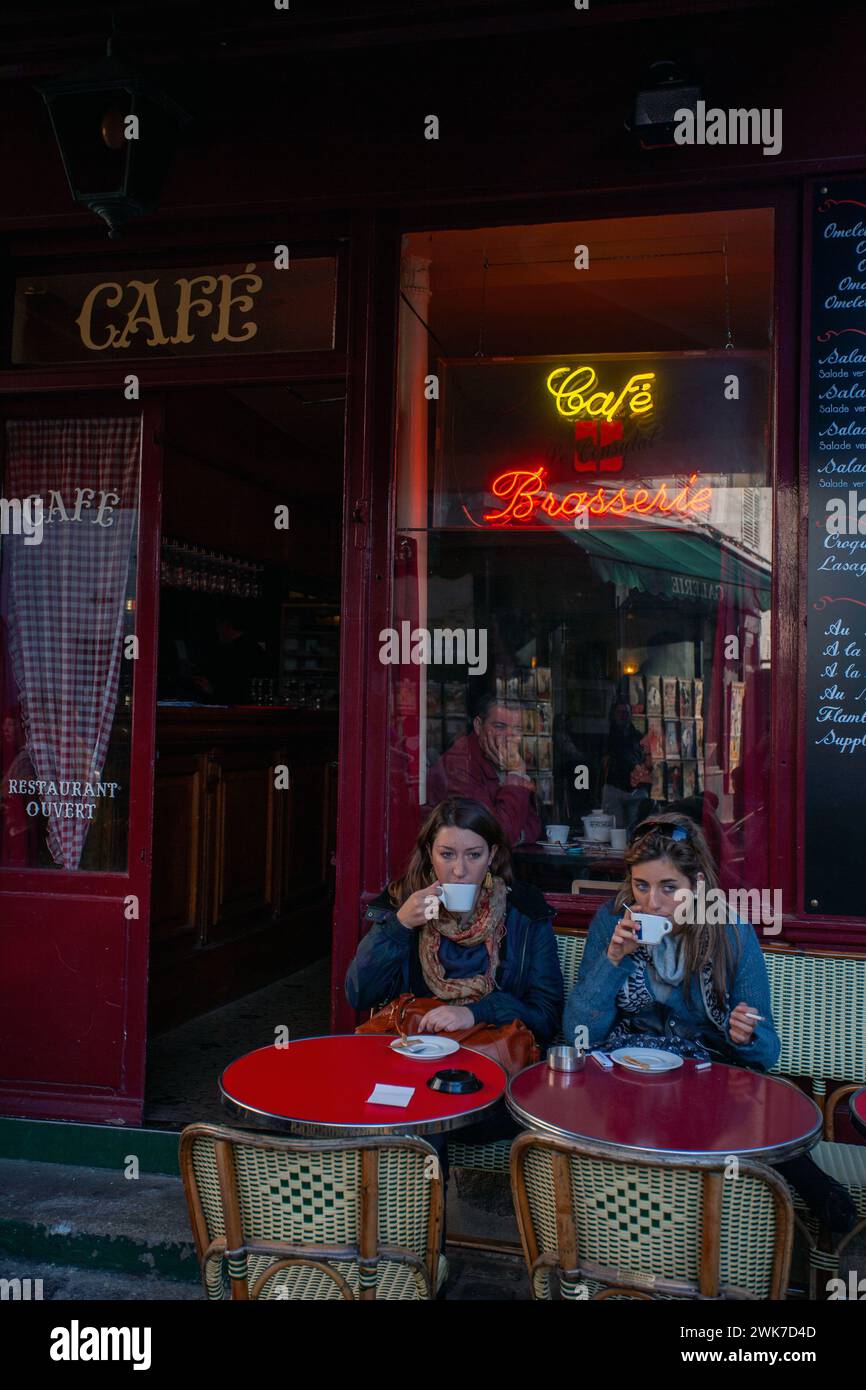 Zwei Freundinnen, die draußen im typischen Café Brassiere in Paris einen Kaffee trinken. Stockfoto