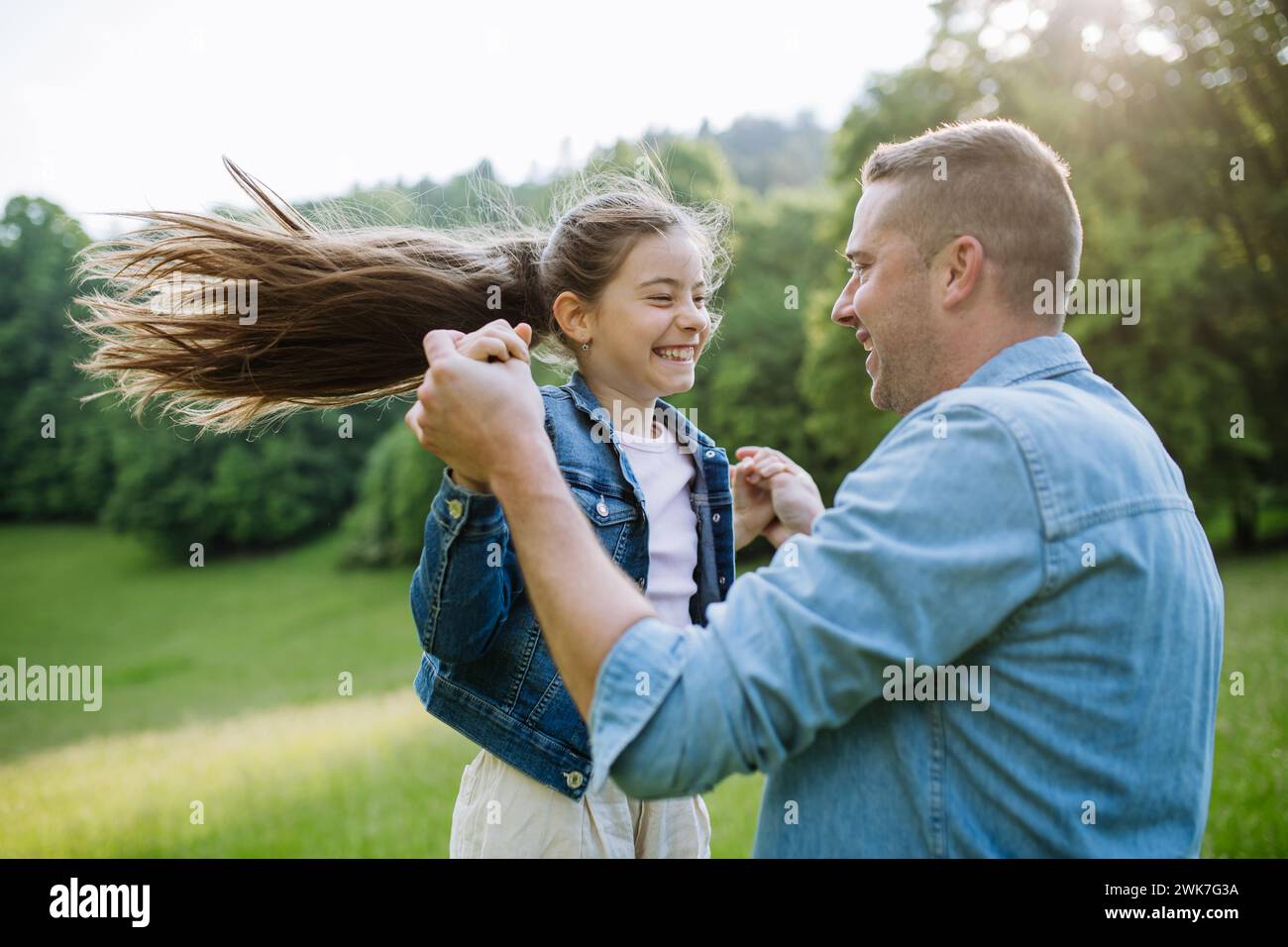 Vater mit Tochter, spielt auf der Wiese, rennt, hat Spaß. Vatertag und Vaterliebe. Stockfoto