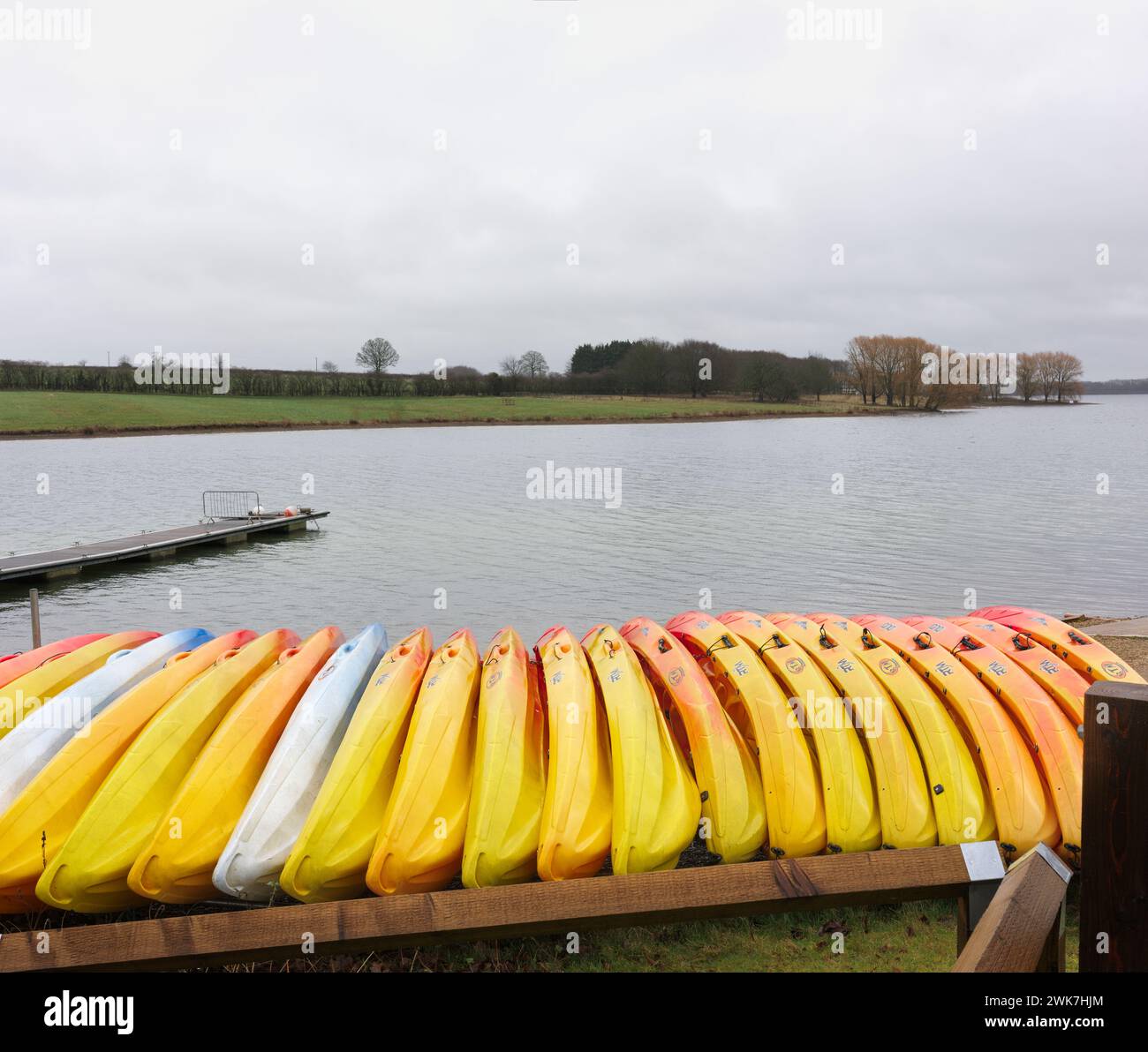 Eine Vielzahl von Kanus am Ufer des Rutland Water Lake (Reservoir) an einem nassen, regnerischen, nebeligen Tag. Stockfoto
