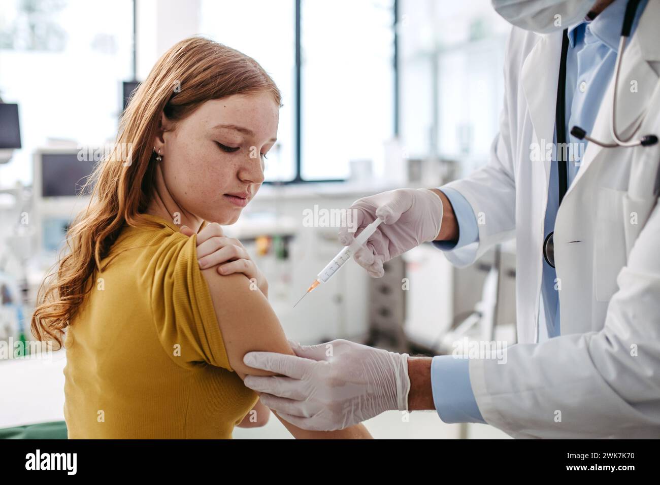 Arzt, Kinderarzt, der Impfstoff in den Arm eines Teenagers injiziert. Konzept der Gesundheitsvorsorge und Impfungen für Jugendliche, Immunisierung. Stockfoto