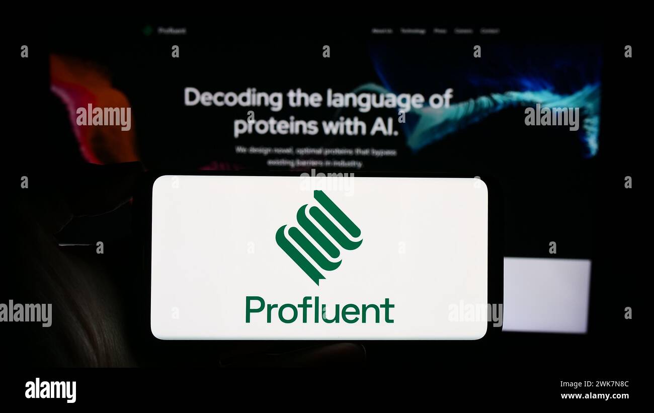 Person, die ein Mobiltelefon mit dem Logo des US-Biotechnologie-Unternehmens Profluent Bio vor der Business-Webseite hält. Schwerpunkt auf dem Display des Telefons. Stockfoto