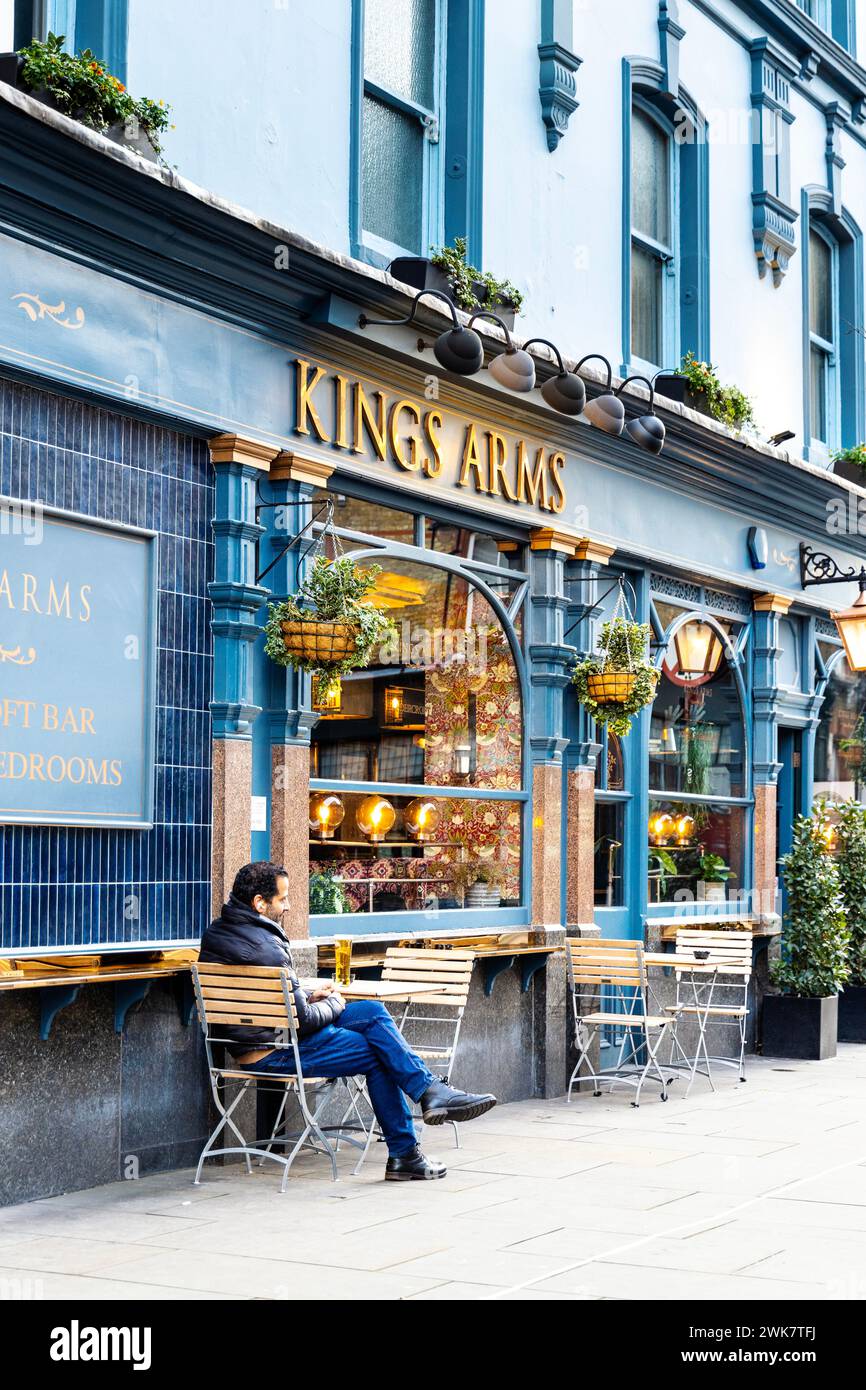 Mann sitzt vor dem Kings Arms Pub in Fitzrovia, London, England Stockfoto