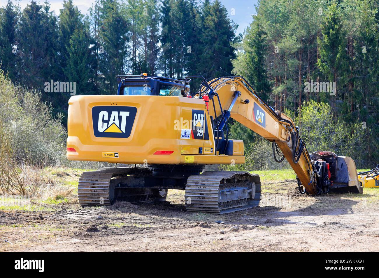 Hydraulikbagger Cat 323 auf einem Hof in der Nähe der Brückenbaustelle an einem sonnigen Frühlingstag. Salo, Finnland. Mai 2022. Stockfoto