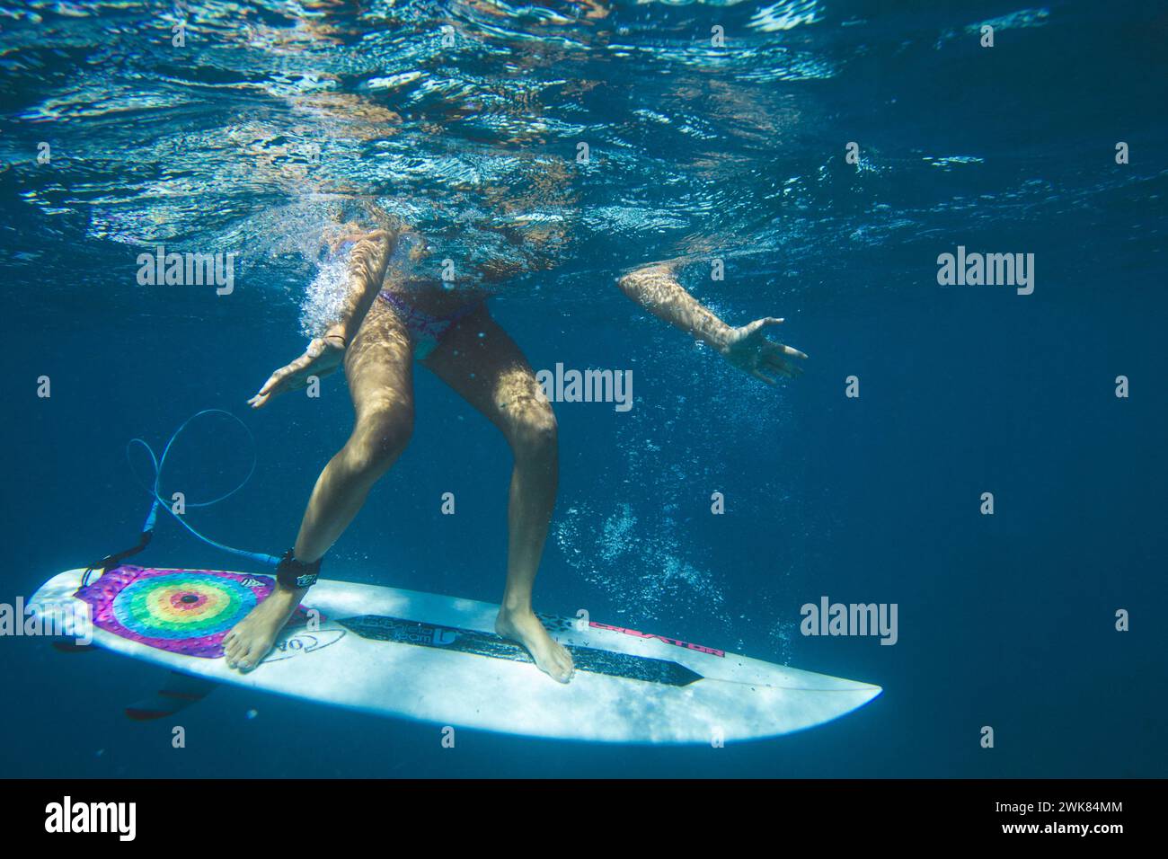 Eine Surferin steht auf ihrem Brett unter Wasser Stockfoto
