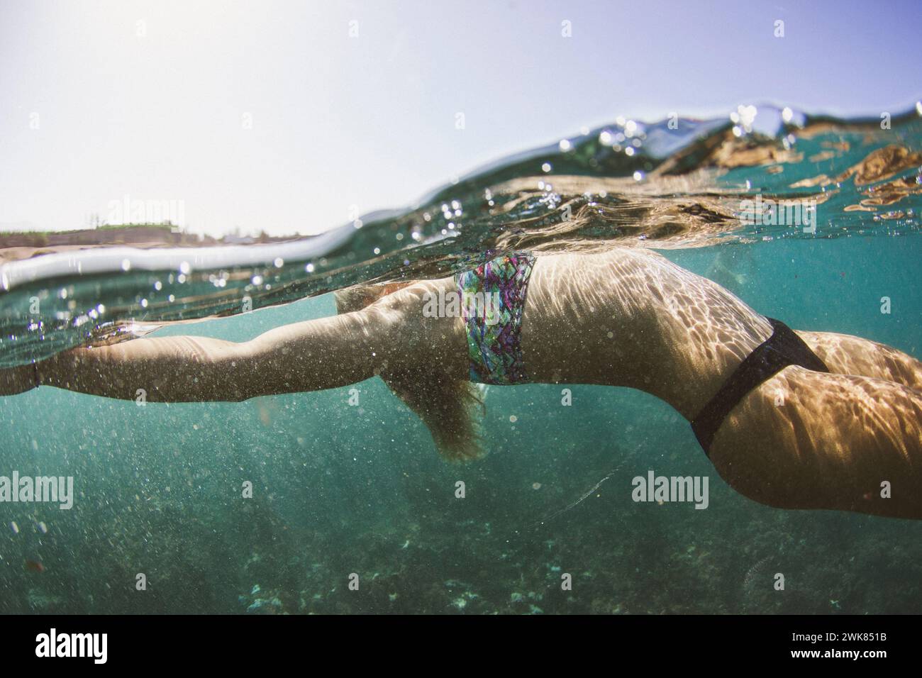 Ein Mädchen in Einem Bikini liegt auf der Meeresoberfläche Stockfoto