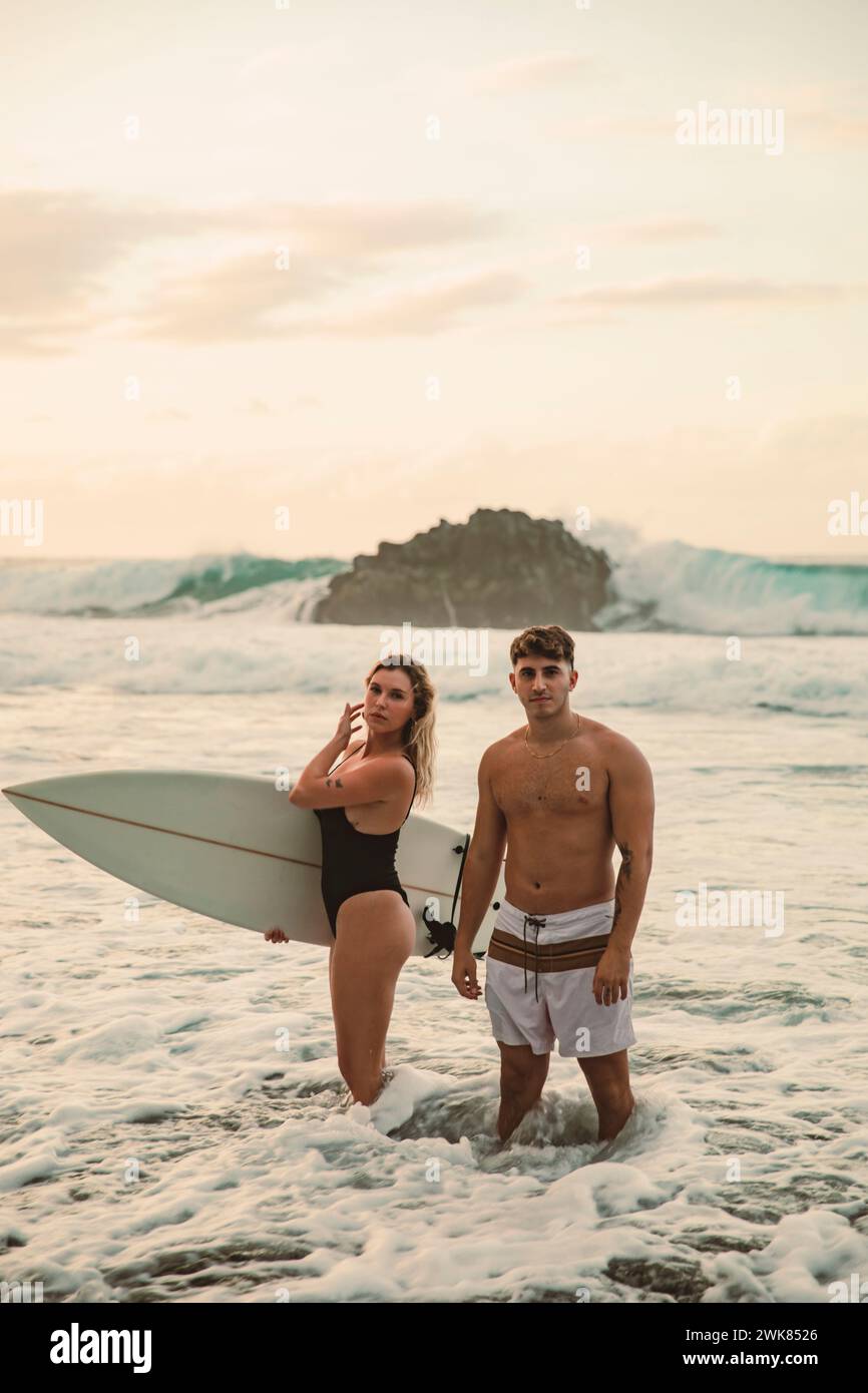 Paare surfen an einem schönen Strand auf Teneriffa während Sonnenuntergang Stockfoto