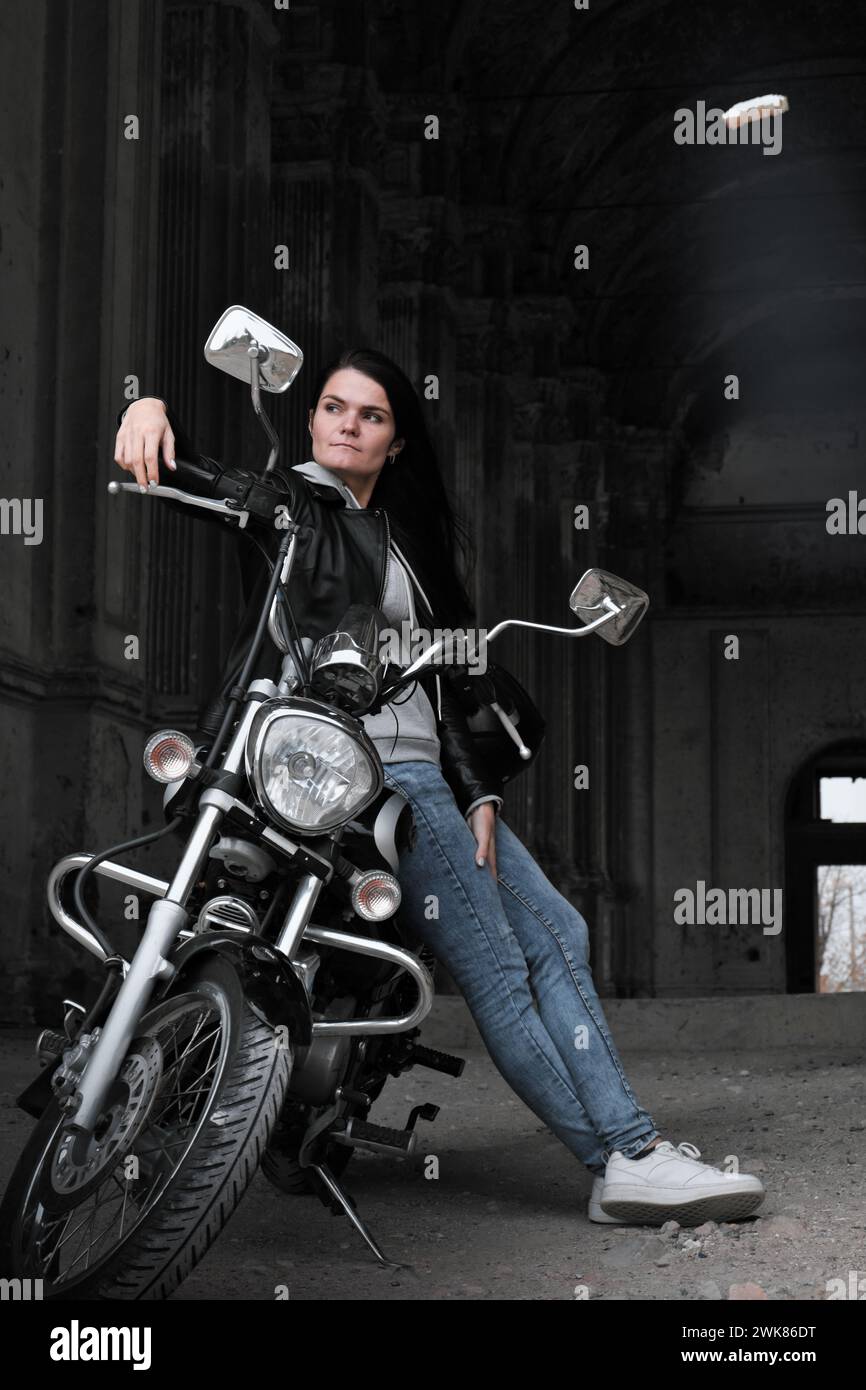 Porträt einer Frau in einer Lederjacke auf einem Vintage-Motorrad Stockfoto