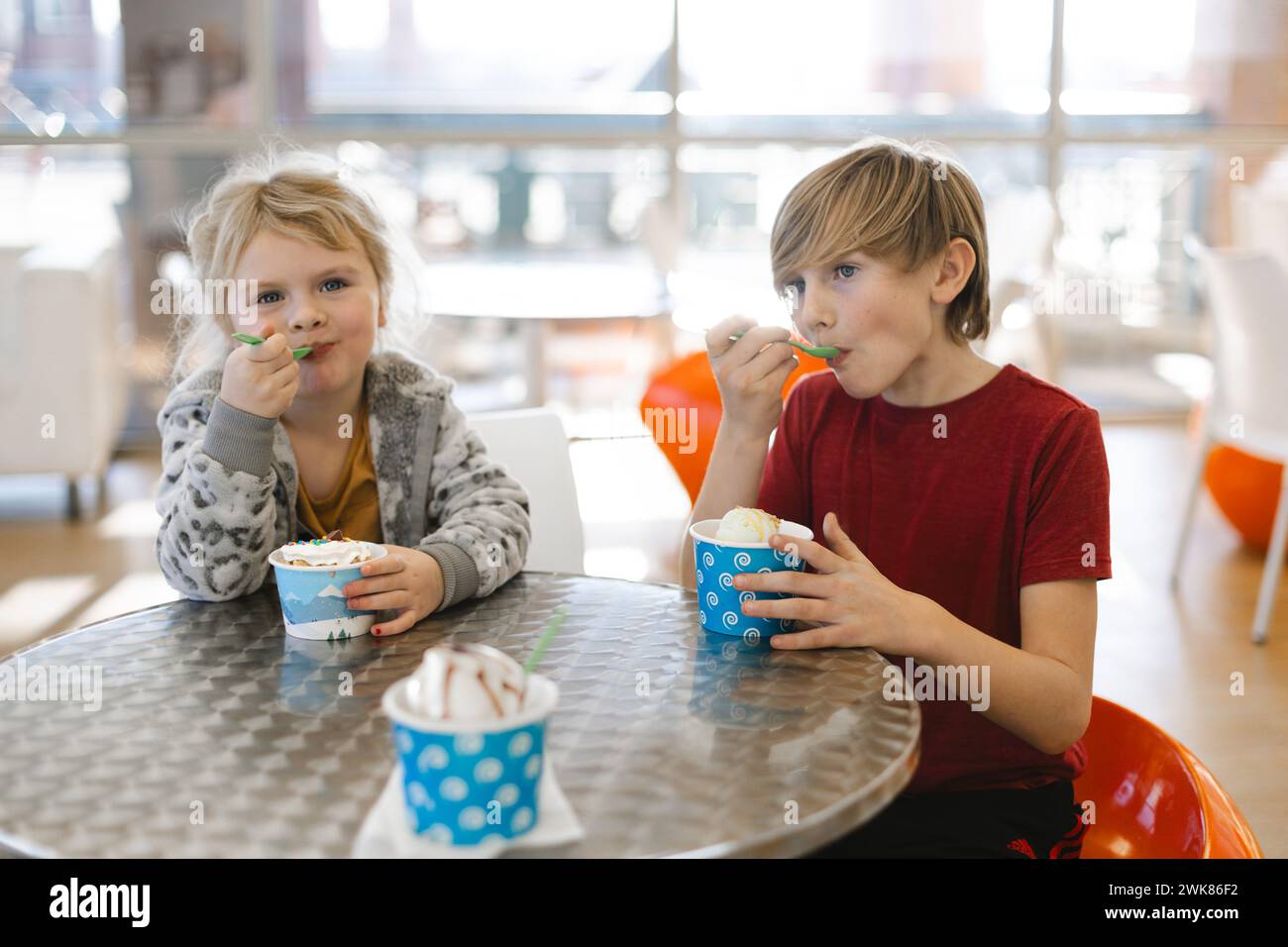 Kinder essen Eis in einem bunten Süßwarenladen Stockfoto