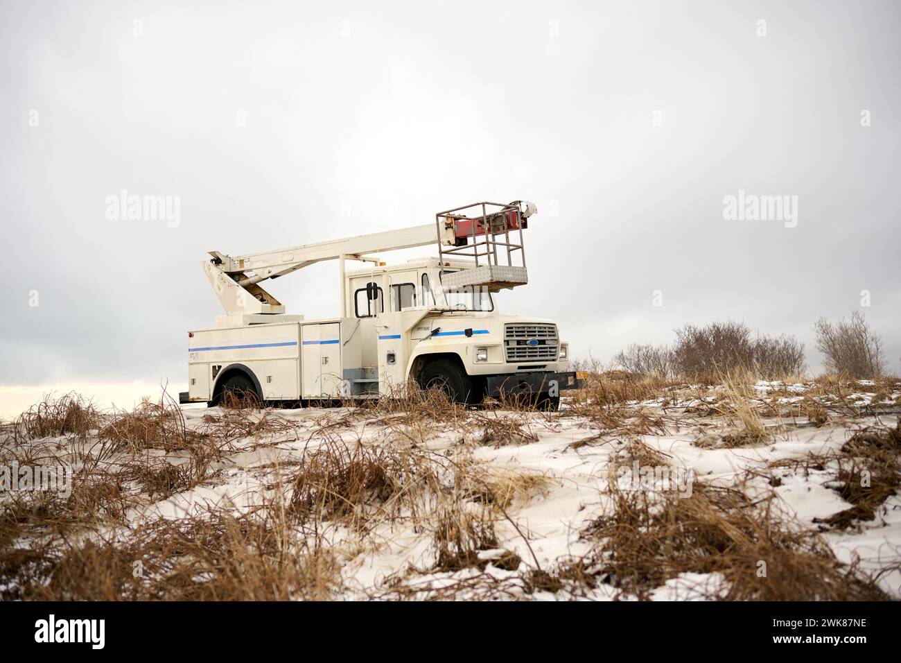 Kranwagen parkt im Winter auf verschneiten Wiesen Stockfoto