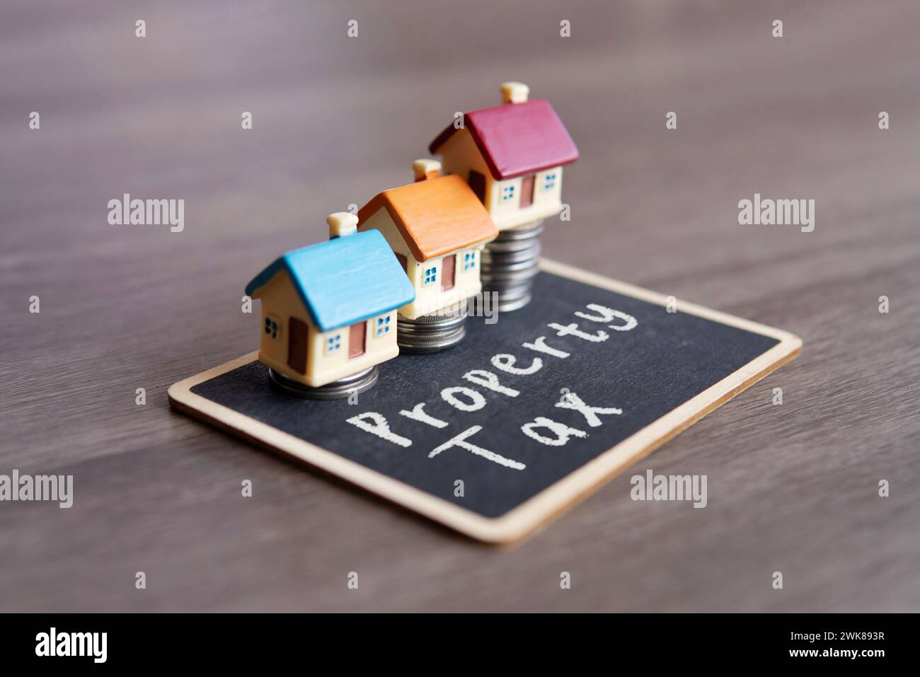 Spielzeughaus und Tafel mit Text GRUNDSTEUER. Immobilienkonzept. Stockfoto