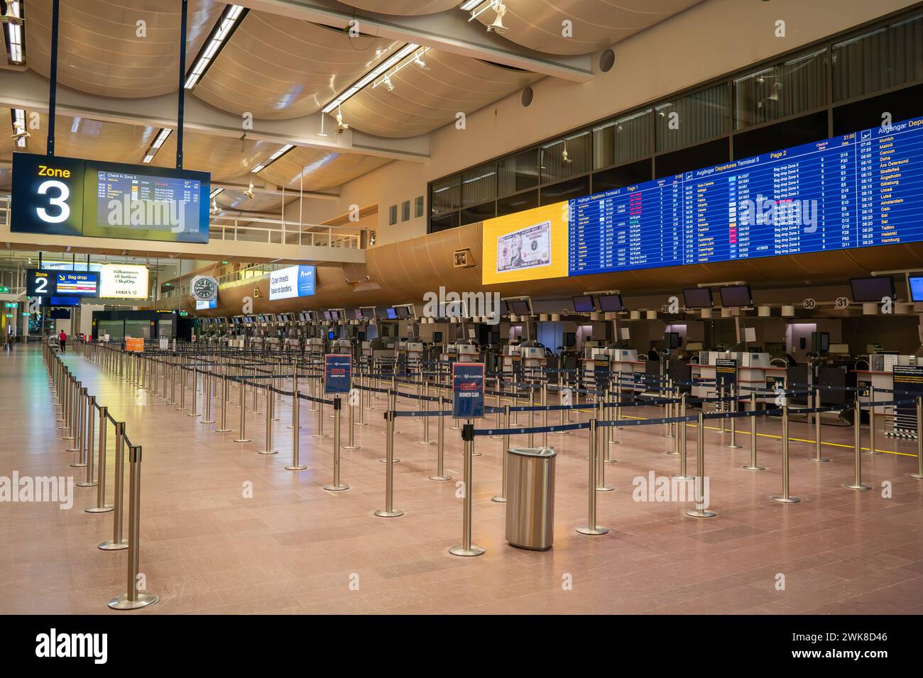 Ein leerer Check-in-Bereich am Terminal 5 im Flughafen Stockholm Arlanda, Abflugbildschirm, Schalter und Warteschlangen. Die Wirkung von Fluchtschädigung und Pandemie. Stockfoto