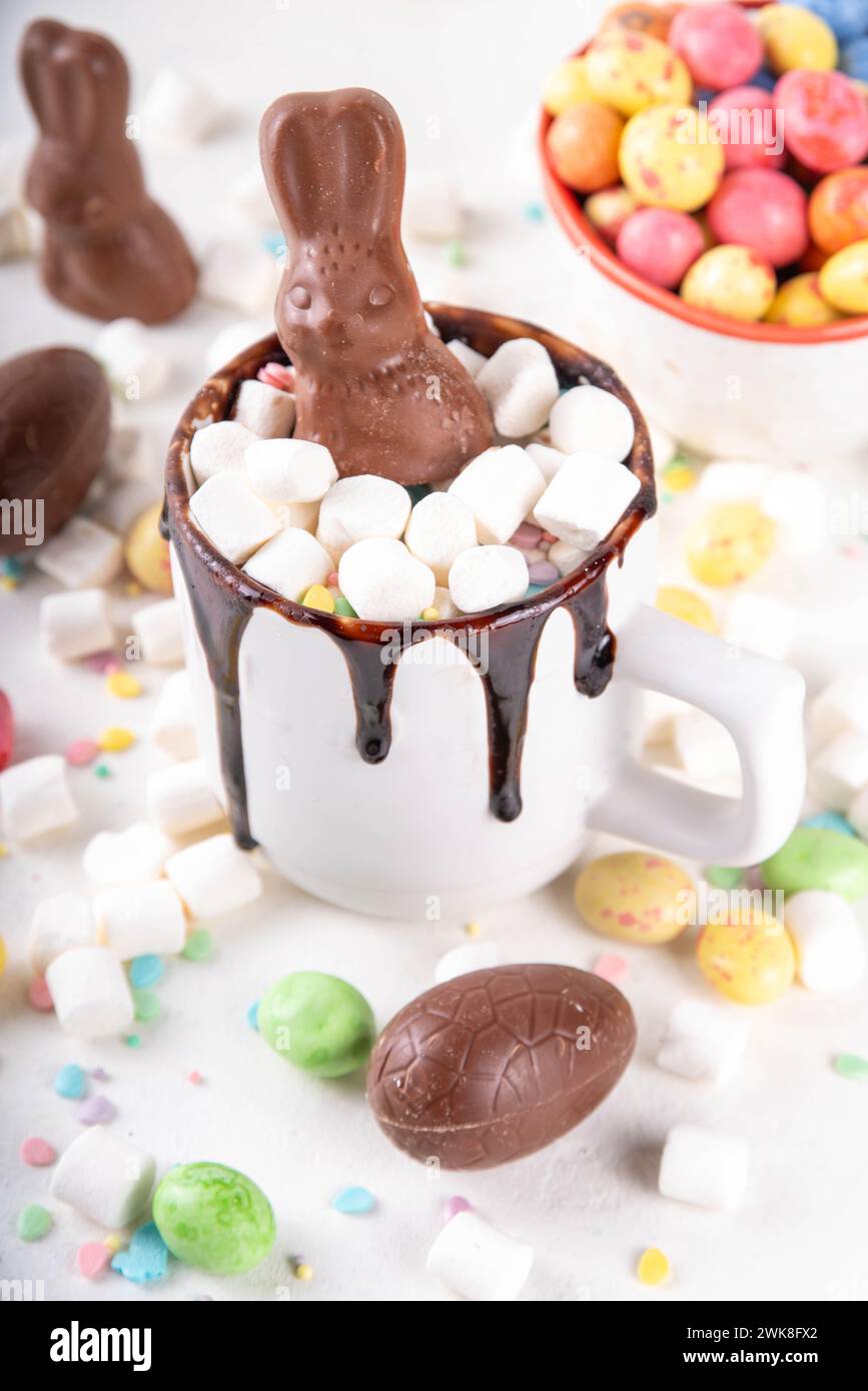 Süßer Osterbecher mit Schokoladeneiern und Kaninchen, leckeres hausgemachtes Kakaorezept mit Ostersymbolen Schokolade und Marshmallow, weiße Küche Stockfoto