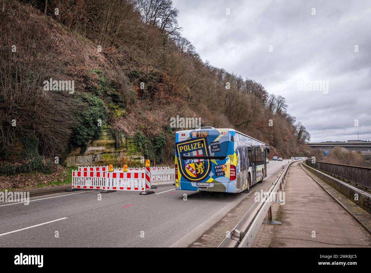 Die Bundesstraße 406 ist am Freitag 16.02.2024 in Saarbrücken-Güdingen wieder halbseitig befahrbar. Die Straße war seit dem 2. Januar 2024 voll gesperrt. Es drohte ein rund 50 Tonnen schwerer Felsbrocken abstürzen. Die Sperrung sorgte für lange Staus auf den Umgehungsstraßen. Vorerst wird der Verkehr mithilfe einer Ampel einspurig an der Gefahrenstelle vorbeiführen. *** Am Freitag, den 16. 02 2024, ist die Bundesstraße 406 in Saarbrücken Güdingen wieder für den Verkehr freigegeben auf einer Seite war die Straße vollständig gesperrt seit dem 2. Januar 2024 drohte Ein rund 50 Tonnen schwerer Felsbrocken zu fallen Stockfoto