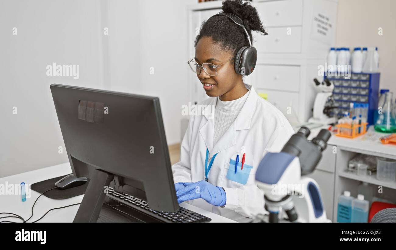 afroamerikanische Wissenschaftlerin, die in einem Labor arbeitet und Daten auf einem Computer analysiert. Stockfoto