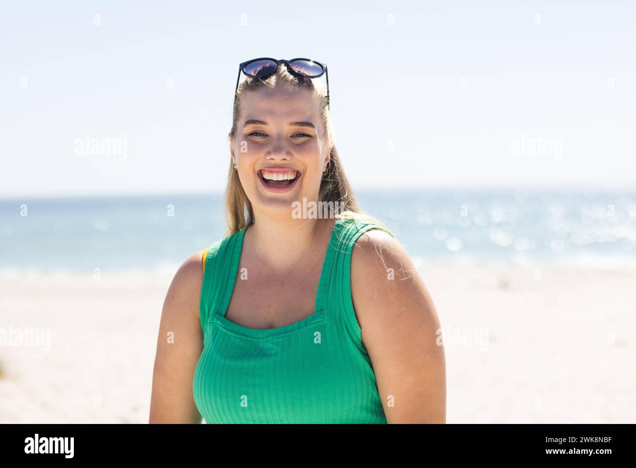 Junge weiße Frau in Übergröße lächelt hell am Strand Stockfoto