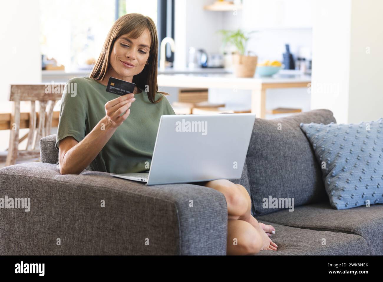 Eine Kaukasierin scheint von zu Hause aus mit Online-Shopping oder -Banking zu tun Stockfoto