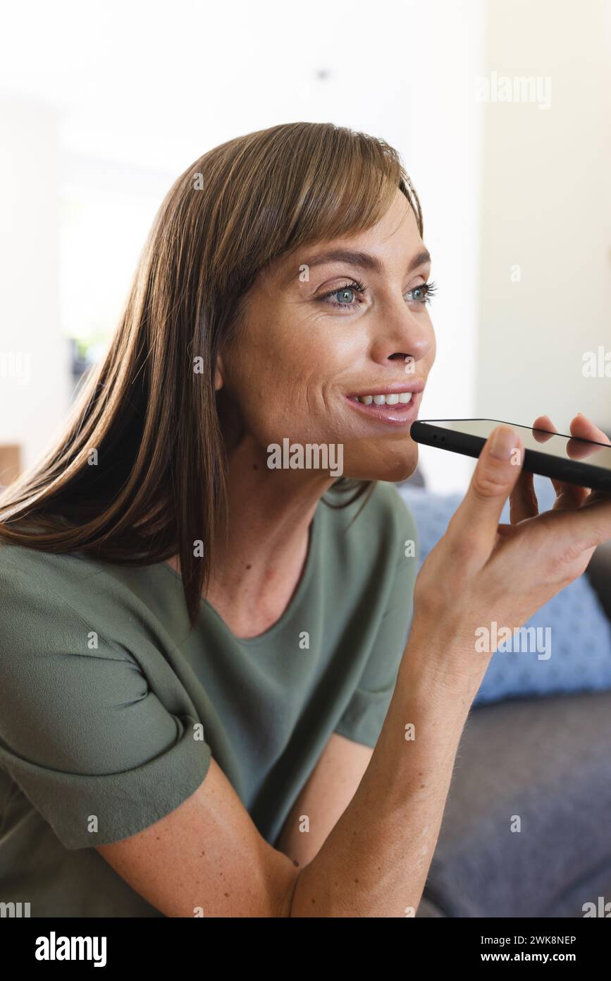 Eine weiße Frau mittleren Alters benutzt Sprachbefehle auf ihrem Smartphone Stockfoto