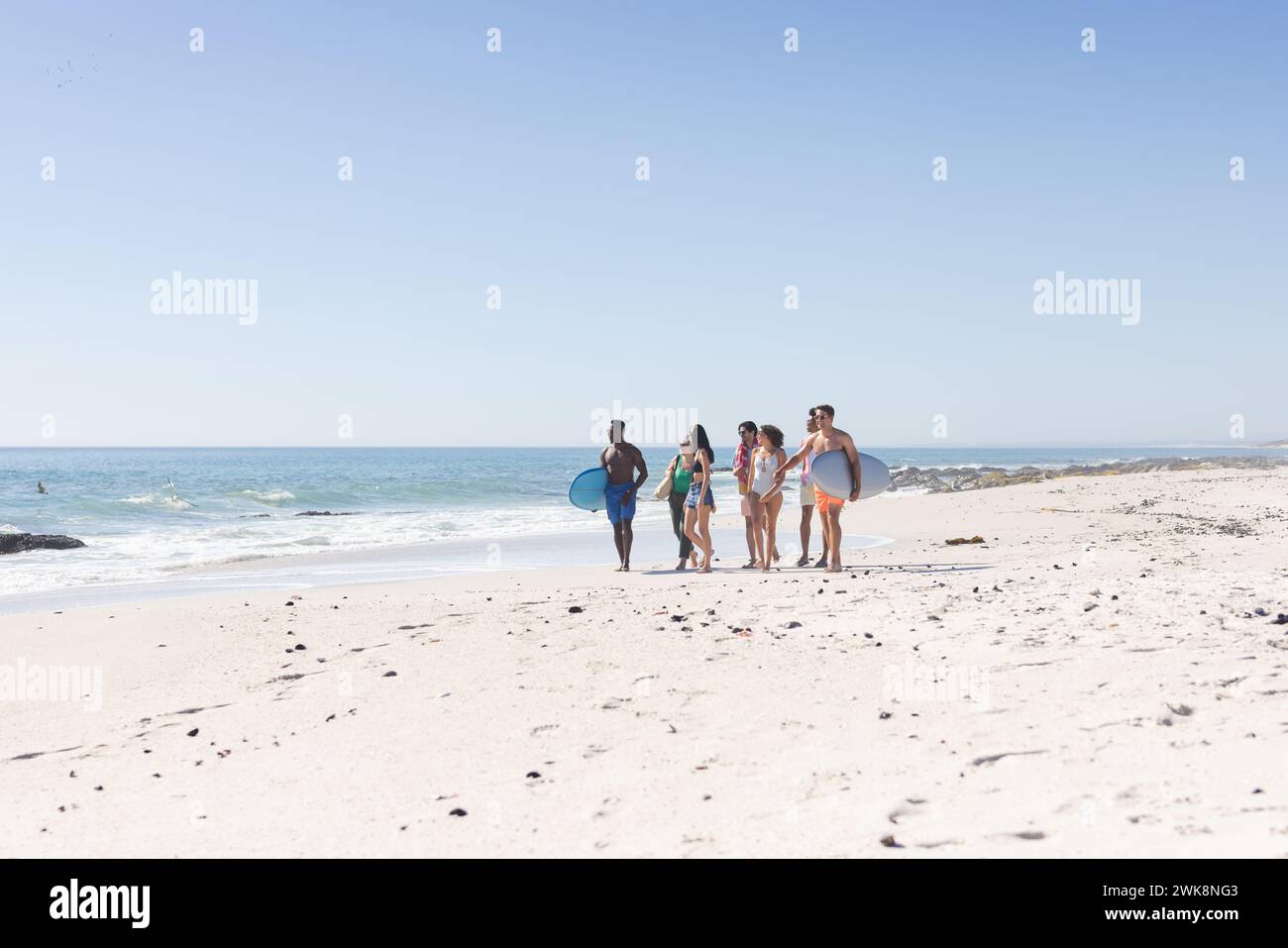 Verschiedene Freunde haben eine schöne Zeit am Strand mit Kopierraum Stockfoto