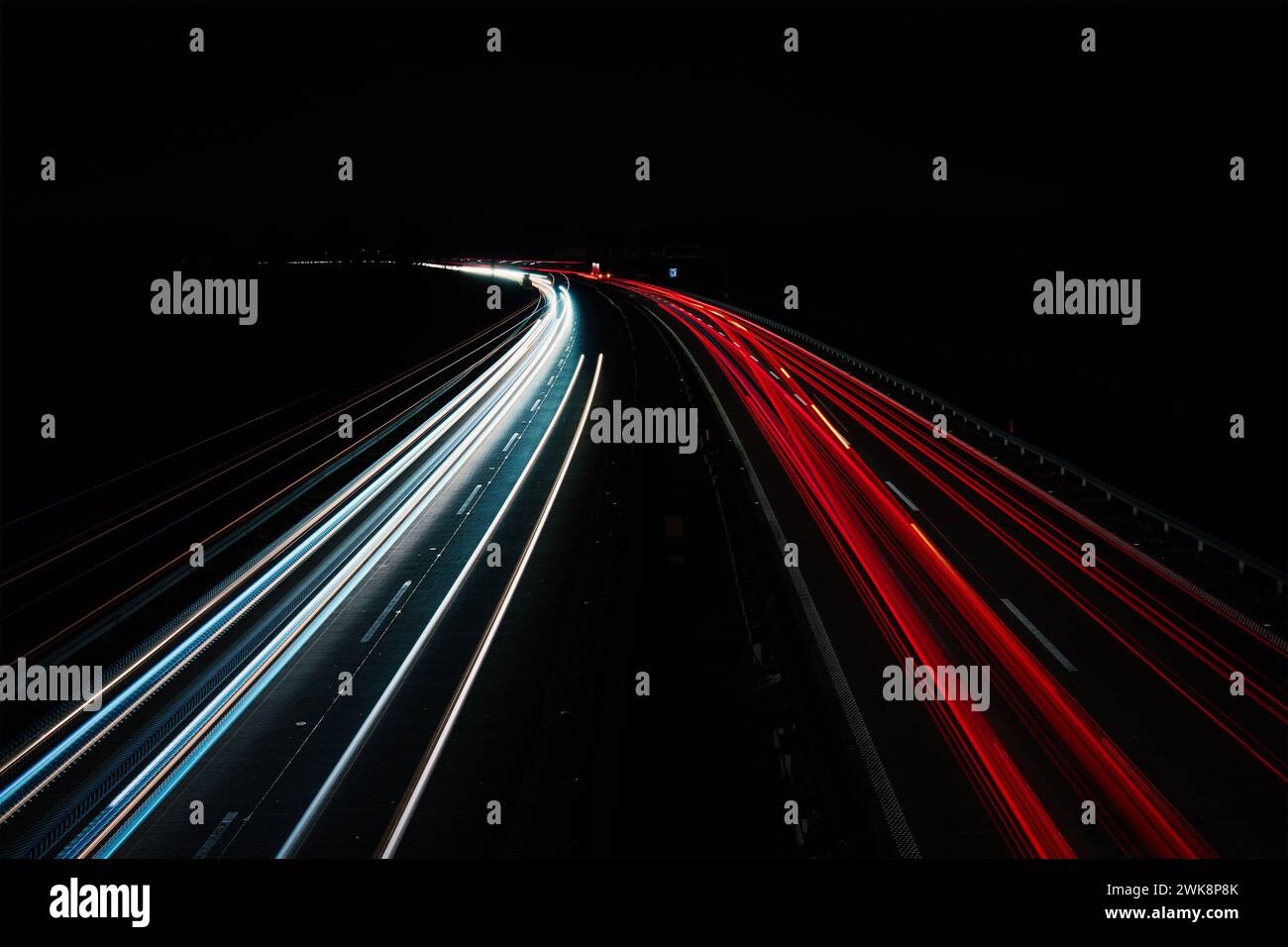 Lichtspuren auf dem Highway bei Nacht. Rush Hour auf der Autobahn mit glühenden Autoscheinwerfern, langer Exposition Stockfoto