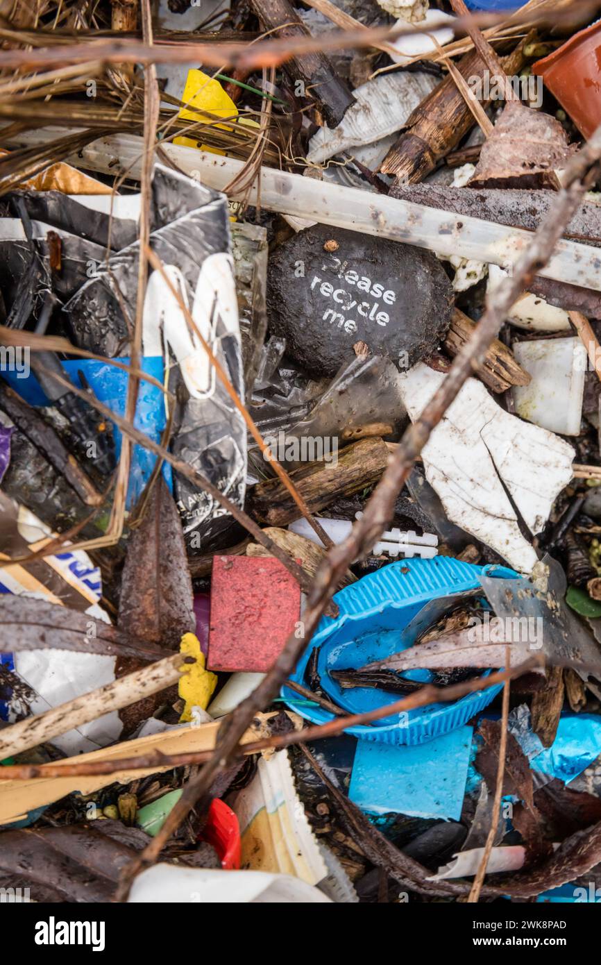 An den Ufern eines Reservoirs angespült, einschließlich Plastikdeckel, süße und knusprige Verpackungen und einem Flaschendeckel mit der Aufschrift „Bitte recyceln Stockfoto