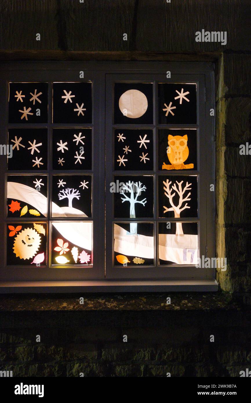 Ein Hausfenster, das in Abschnitte unterteilt ist, mit weihnachtsszenen in jeder. Stockfoto