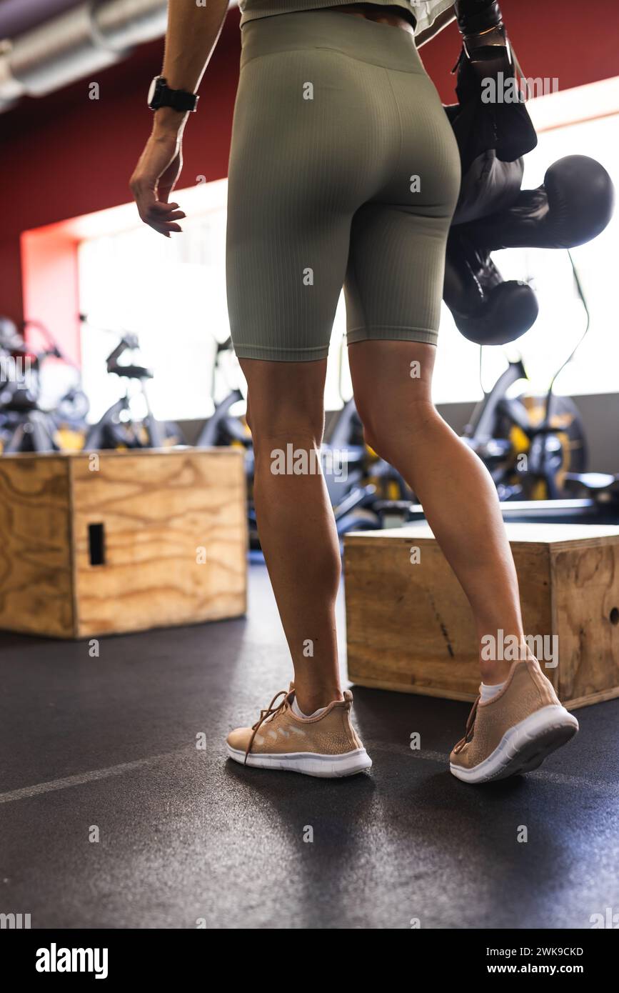 Die junge Kaukasierin im Fitnessstudio hält Boxhandschuhe und hat Kopierraum Stockfoto