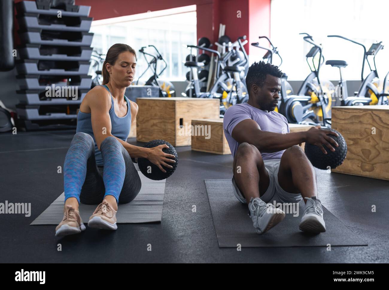 Ein vielseitiges Paar, das im Fitnessstudio trainieren und sich auf die gemeinsame Stärkung der Rumpfmuskulatur konzentrieren kann Stockfoto