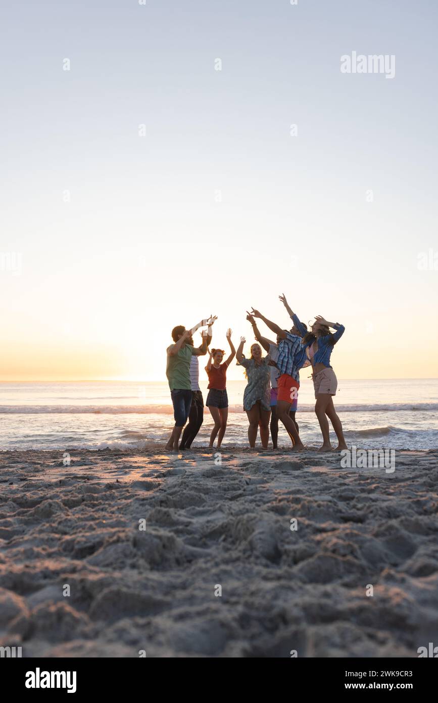 Freunde feiern am Strand bei Sonnenuntergang mit Kopierraum Stockfoto