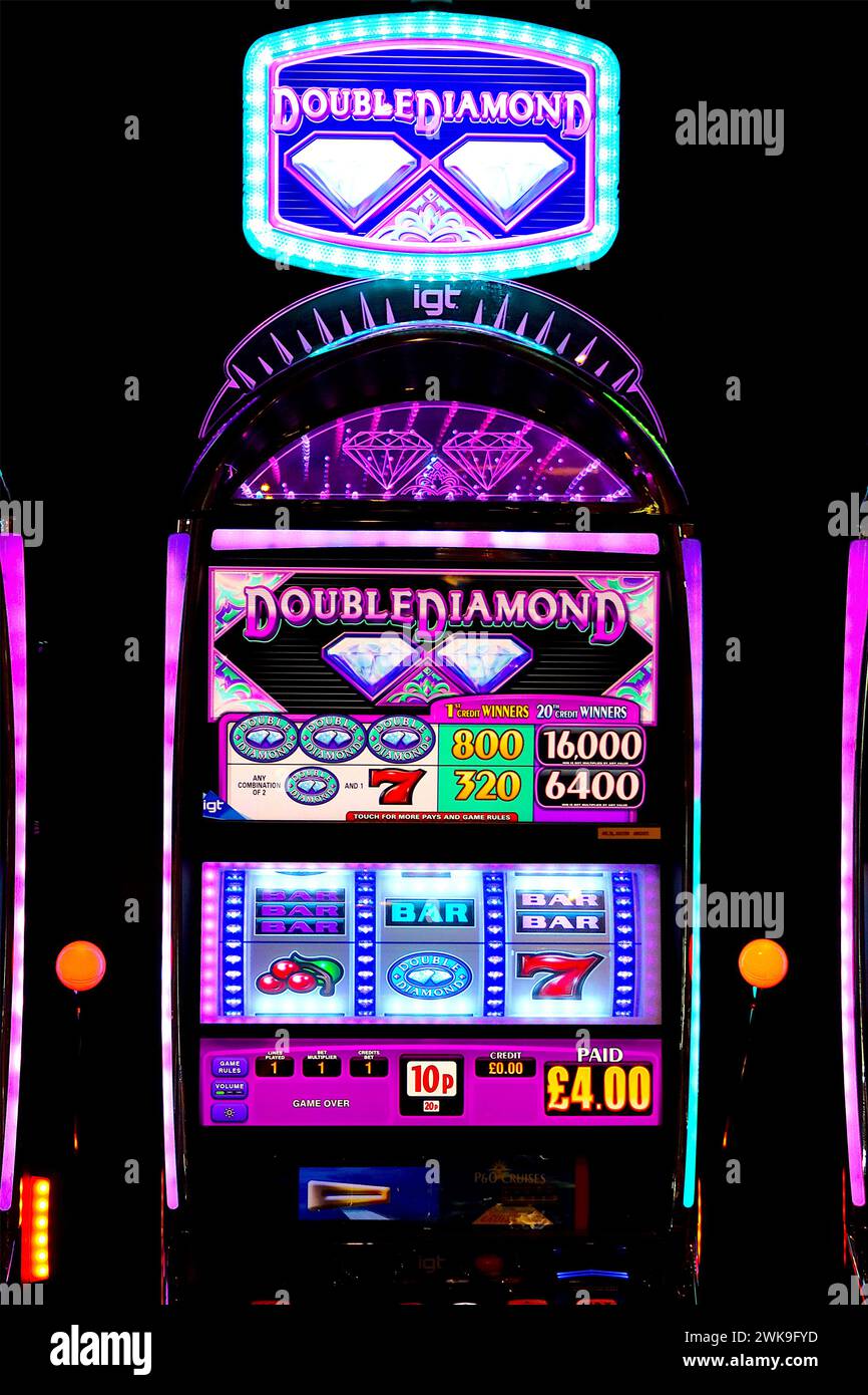 Der IGT Double Diamond Videospielautomat mit beleuchtetem Bauch und rautenförmiger Kopfleiste zieht Spieler in einer Spielhalle an. Stockfoto