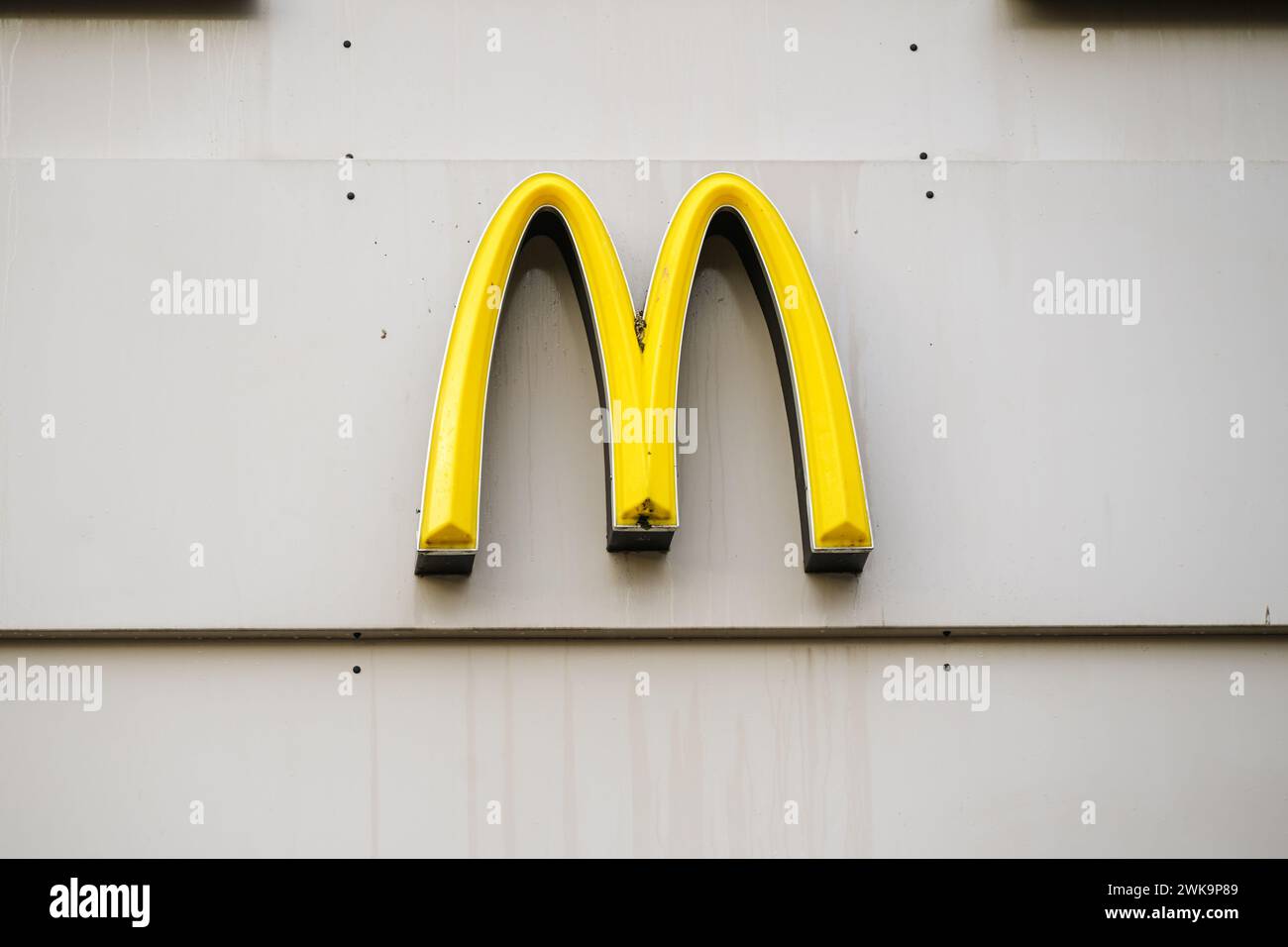 Rostock, Deutschland, 26. Januar 2024: Golden Arches Markenlogo der Mac Donalds Corporation auf einer grauen Gebäudefassade im Stadtzentrum, multinationales fa Stockfoto
