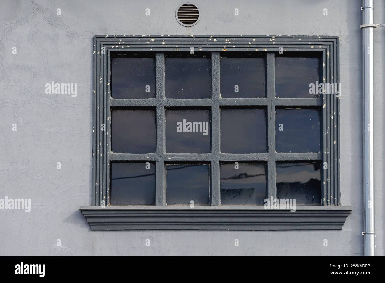 Dunkel getöntes Fenster aus schwarzem Glas im Industriebau Stockfoto