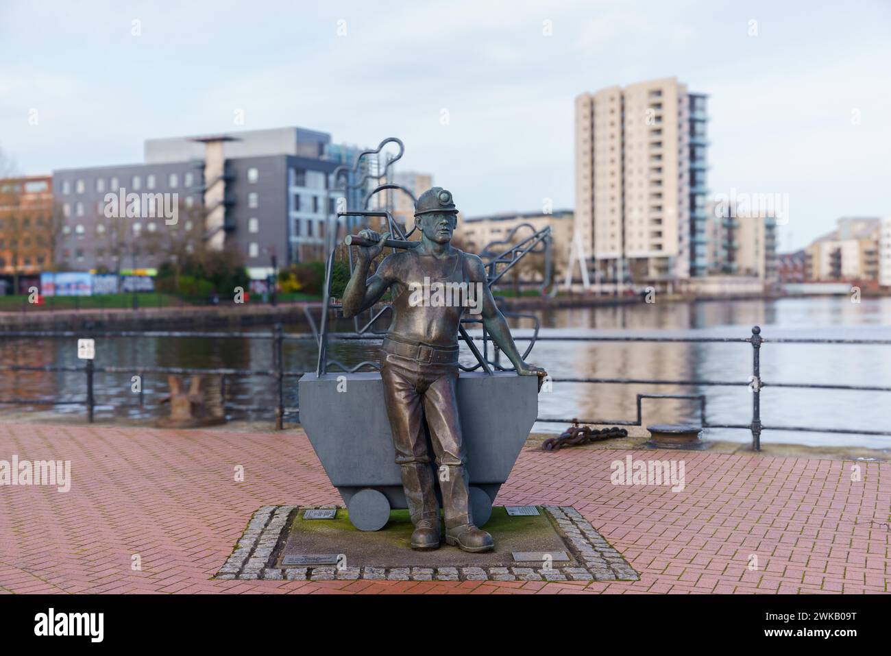 „Von der Grube zum Hafen“ eine Statue von John Clinch an der Waterfront in Cardiff Bay, die zu Ehren der Kohleindustrie in Südwales errichtet wurde. Stockfoto