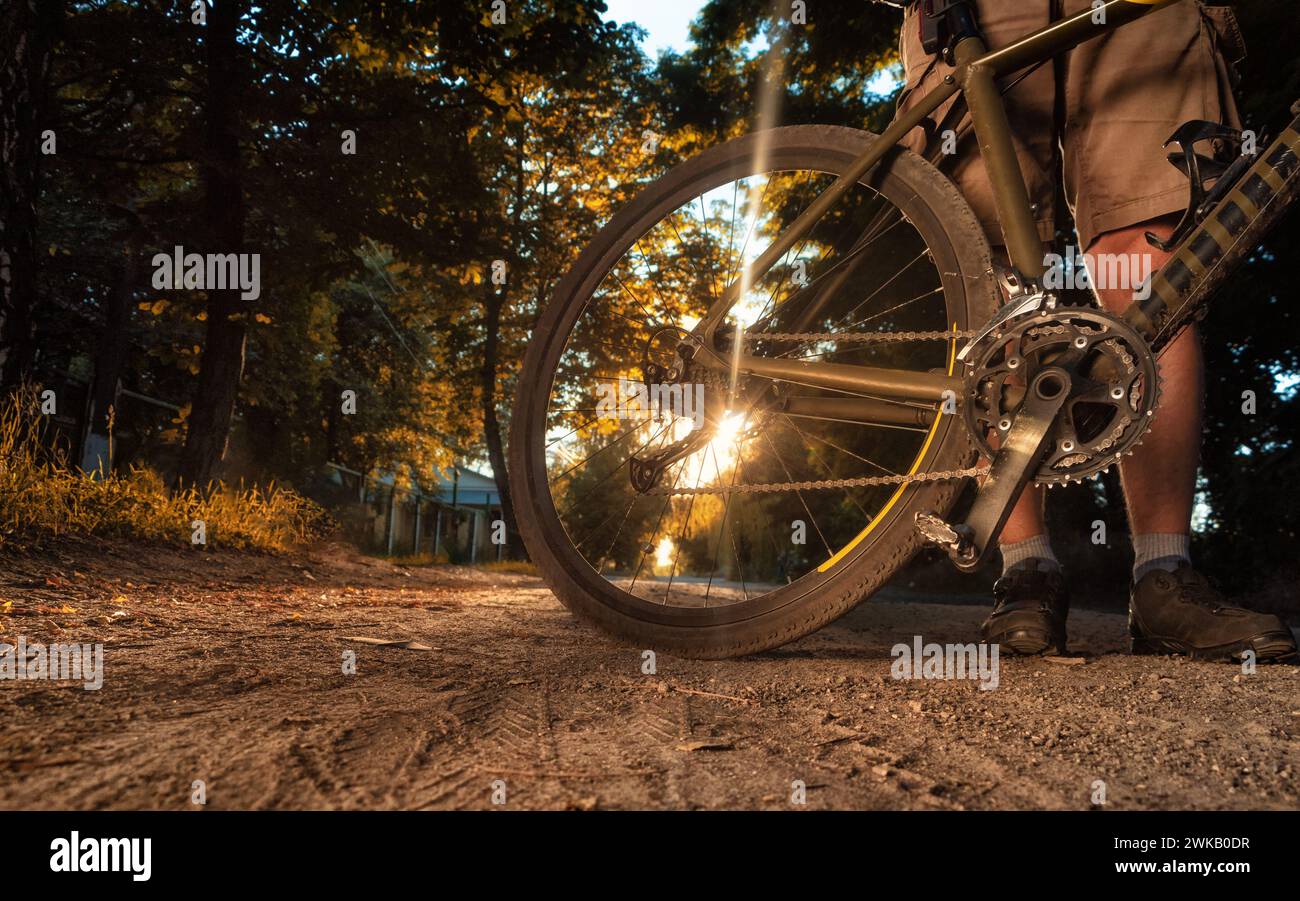 Radfahrer stehen mit dem Fahrrad auf unbefestigtem Weg am sonnigen Sommertag. Stockfoto