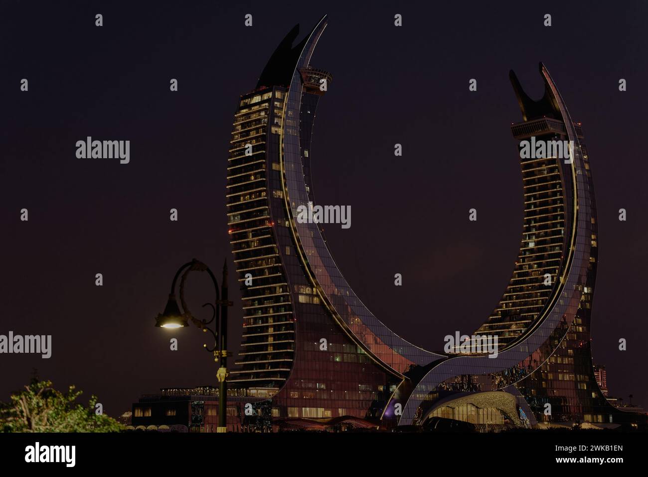 Katara Hospitality Tower, Halbmond Tower, in Lusail, Katar bei Dämmerung zeigt die einzigartige Architektur des beleuchteten Turms Stockfoto