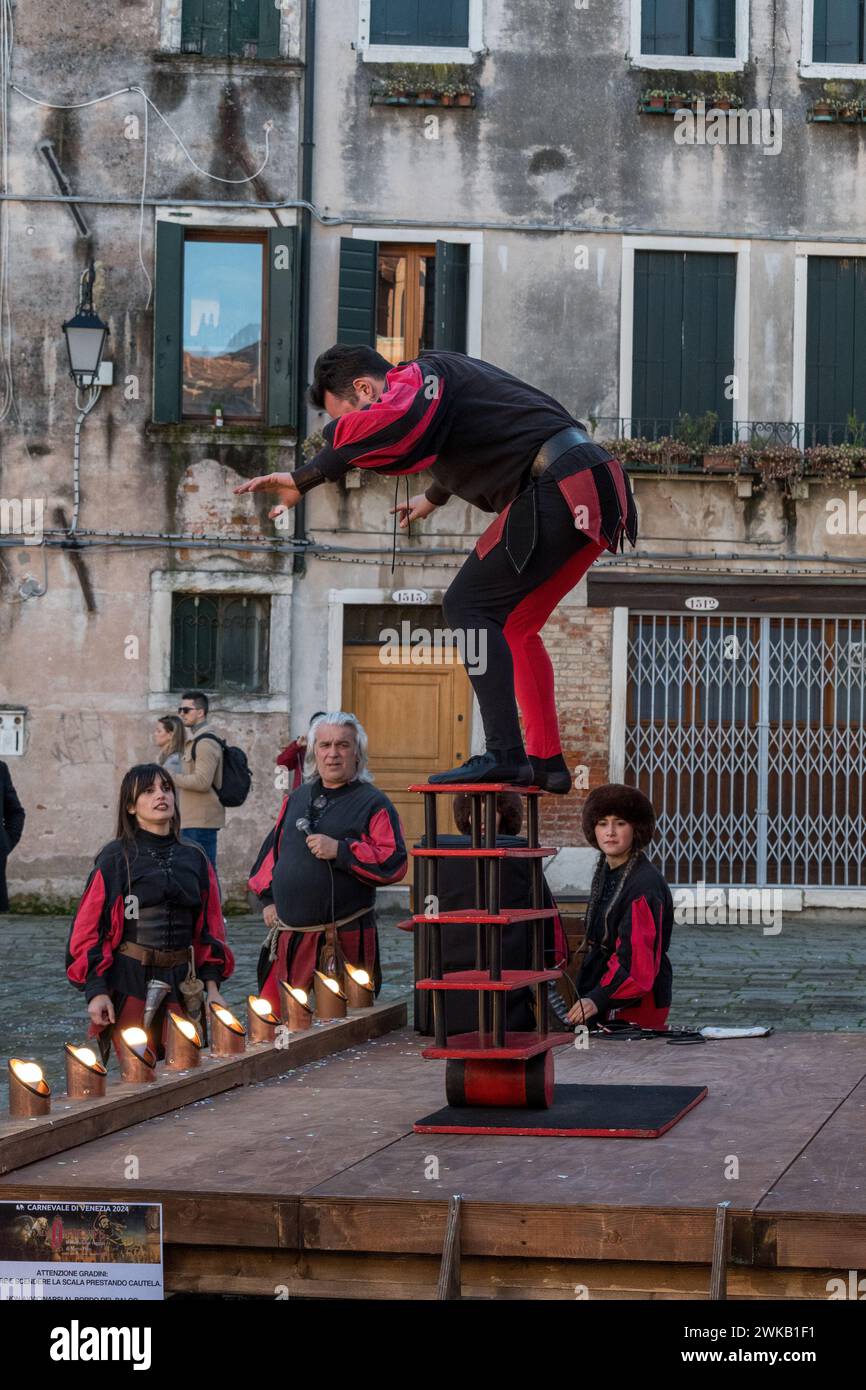 Venedig, Italien - 13. Februar 2024: Sonniger Tag am Karneval von Venedig mit wunderschönen Masken und einer Jongliershow mit einem Drahtseilmesser. Stockfoto