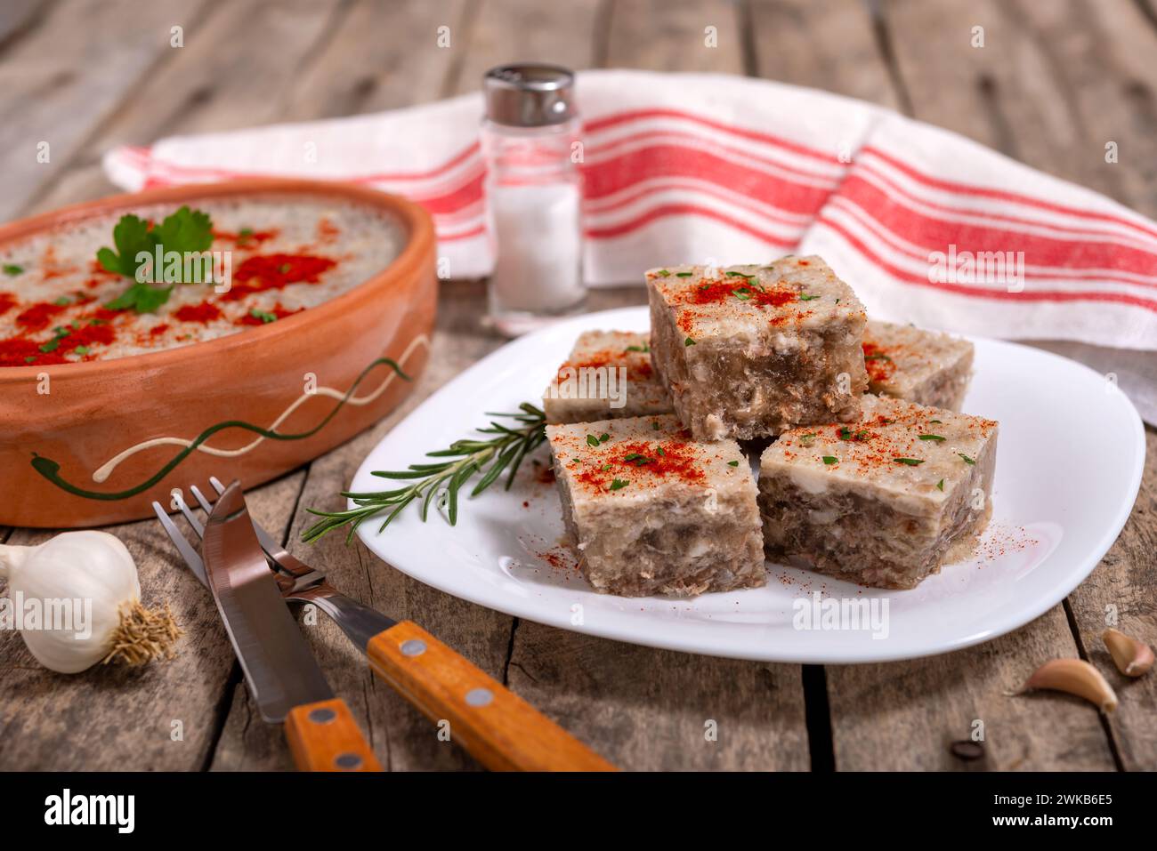 Pihtije: Traditionelles serbisches Gericht. Aspik-Würfel mit Schweinefleisch auf einem Teller. Selektiver Fokus. Stockfoto